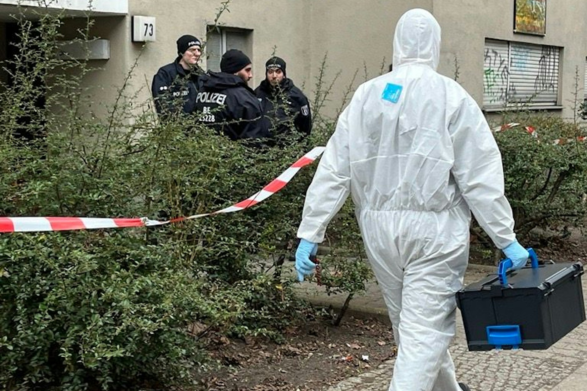 Absperrbänder flattern im Wind, Busse der Polizei stehen vor dem Eingang des Gebäudes. Polizisten stehen Wache und Techniker und Ermittler tragen Kisten aus dem Gebäude. Wer war Daniela Klette, die RAF-Terroristin, eine der meistgesuchten Personen des Landes?