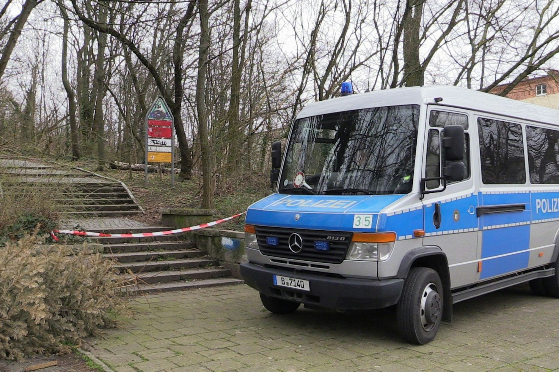 Ein Fahrzeug der Berliner Polizei steht an einem abgesperrten Zugang zum Park.