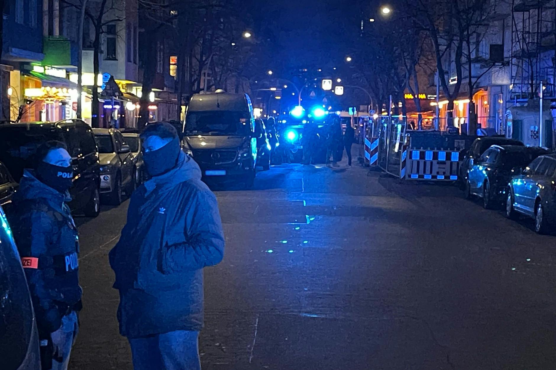 Einsatzwagen der Polizei stehen auf der Grünberger Straße in Friedrichshain. 