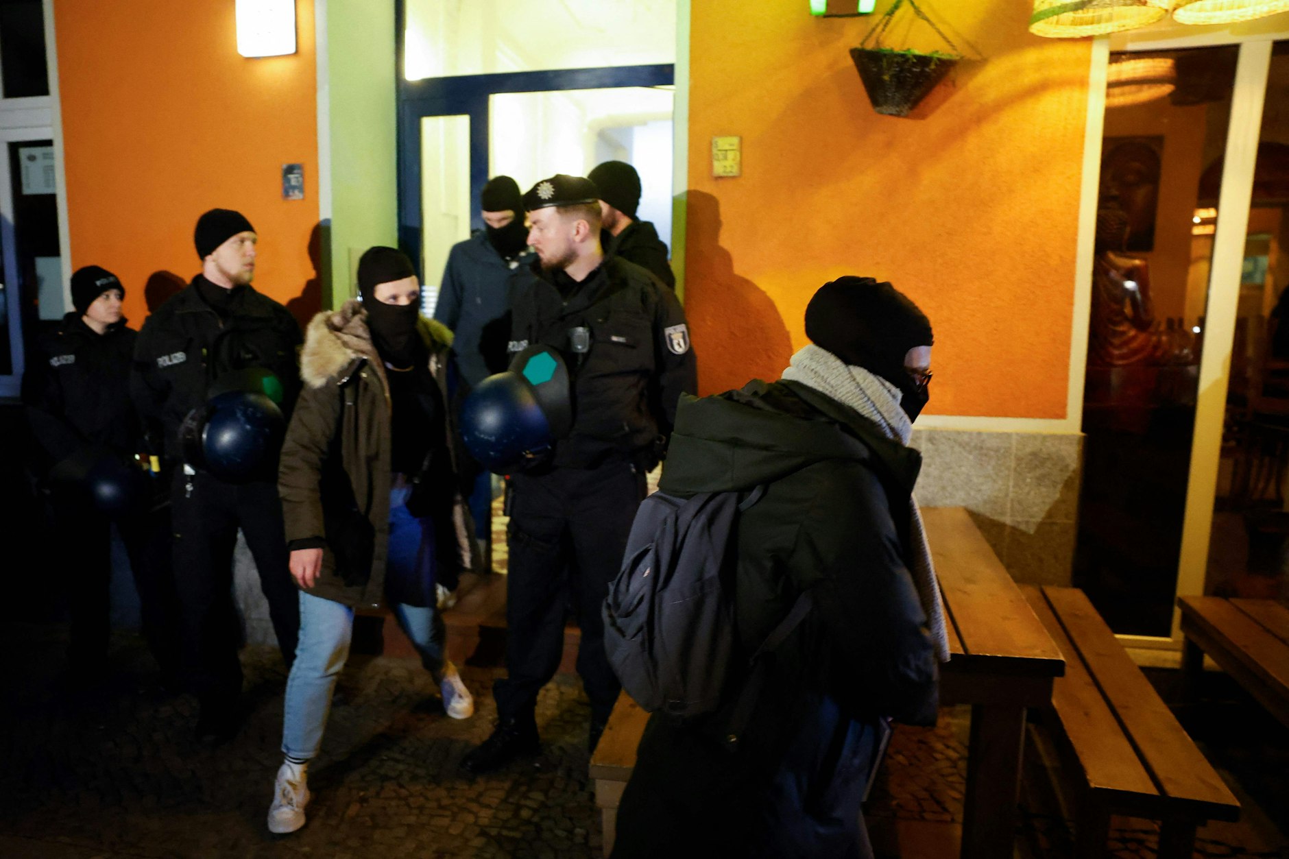 Polizisten sichern den Eingang des Wohnhauses an der Grünberger Straße ab.&nbsp;