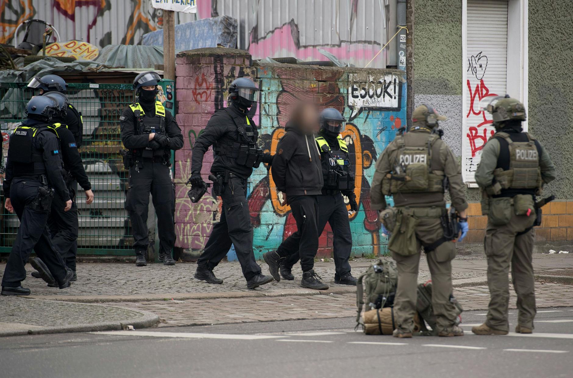 Polizisten nehmen am Sonntagmorgen einen Mann fest und führen ihn ab. Wer er ist, ist noch unklar.