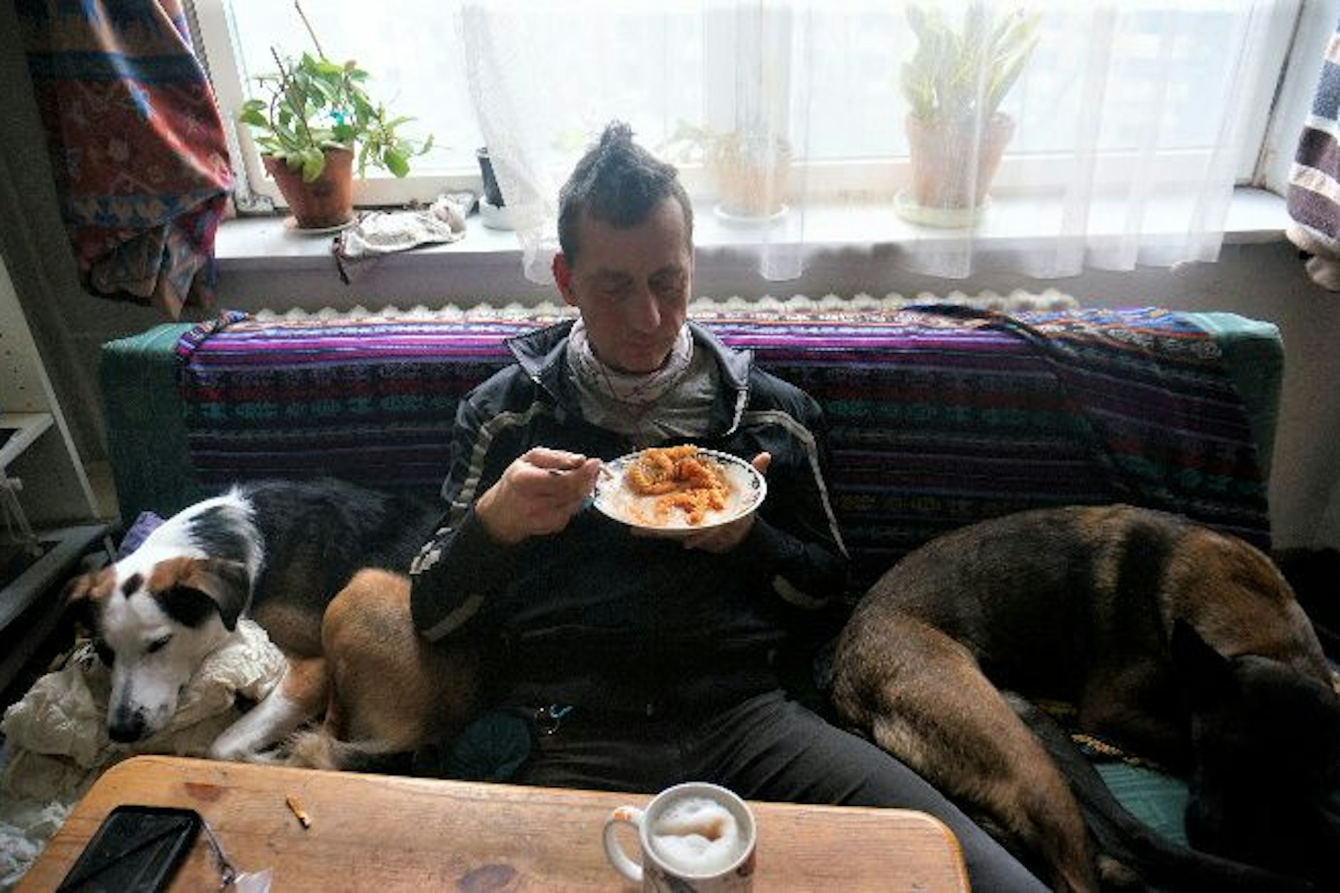 Dieses Foto soll den ehemaligen RAF-Terroristen Burkhard Garweg zeigen - er sitzt essend auf der Couch, an seiner Seite liegen mehrere Hunde.