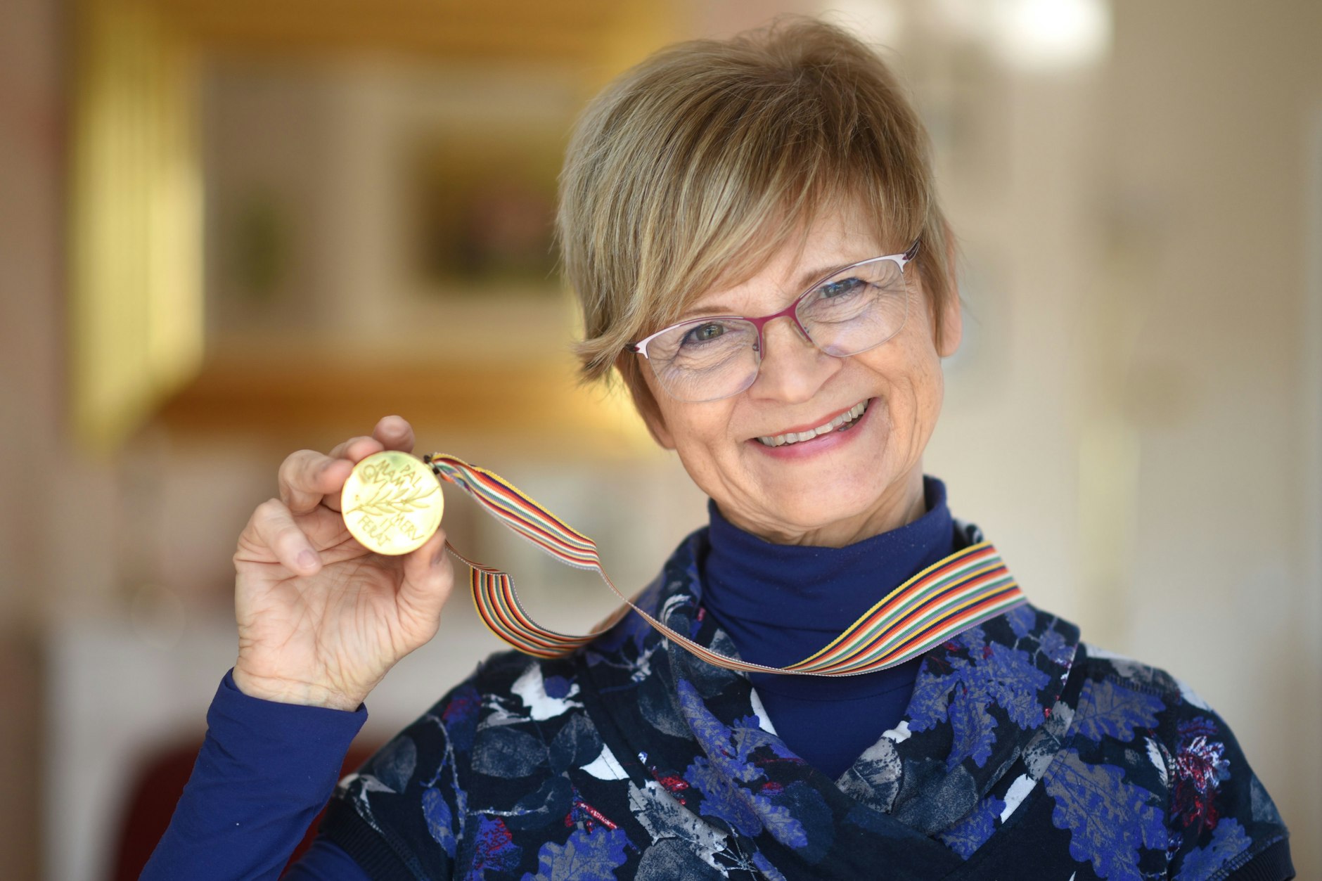 DDR-Eisstar Christine Stüber-Errath zeigt stolz die Goldmedaille. Am 8. März jährt sich der Gewinn ihres WM-Titels zum 50. Mal.