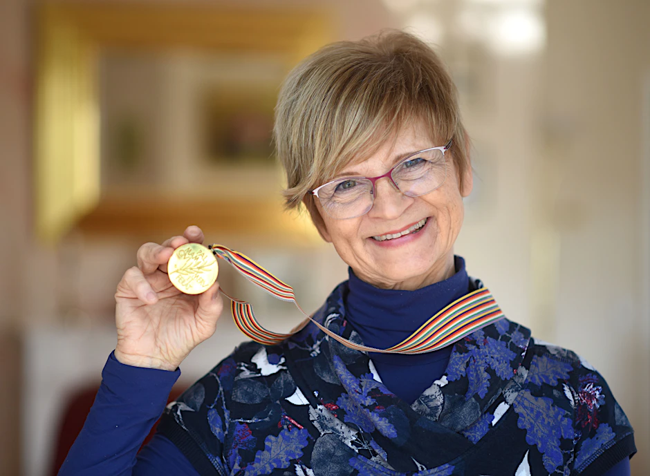 DDR-Eisstar Christine Stüber-Errath zeigt stolz die Goldmedaille. Am 8. März jährt sich der Gewinn ihres WM-Titels zum 50. Mal.