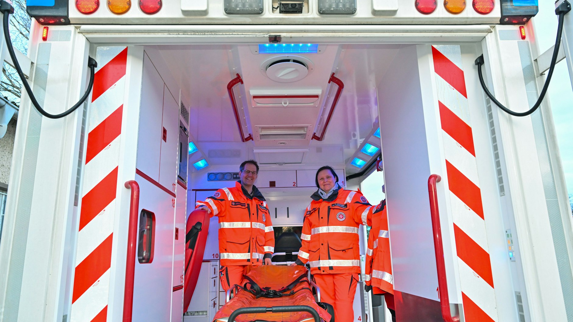 Yvonne Volkmer und Thomas Kopp, ehrenamtliche Mitarbeiter der Johanniter-Unfall-Hilfe, stehen in ihrem umgebauten Einsatzfahrzeug.