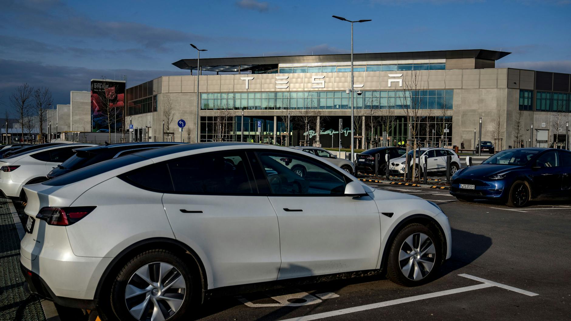 Normalerweise herrscht hier Hochbetrieb: Nur noch wenige Autos parken zurzeit auf der Abstellfläche vor der Tesla-Fabrik in Grünheide.