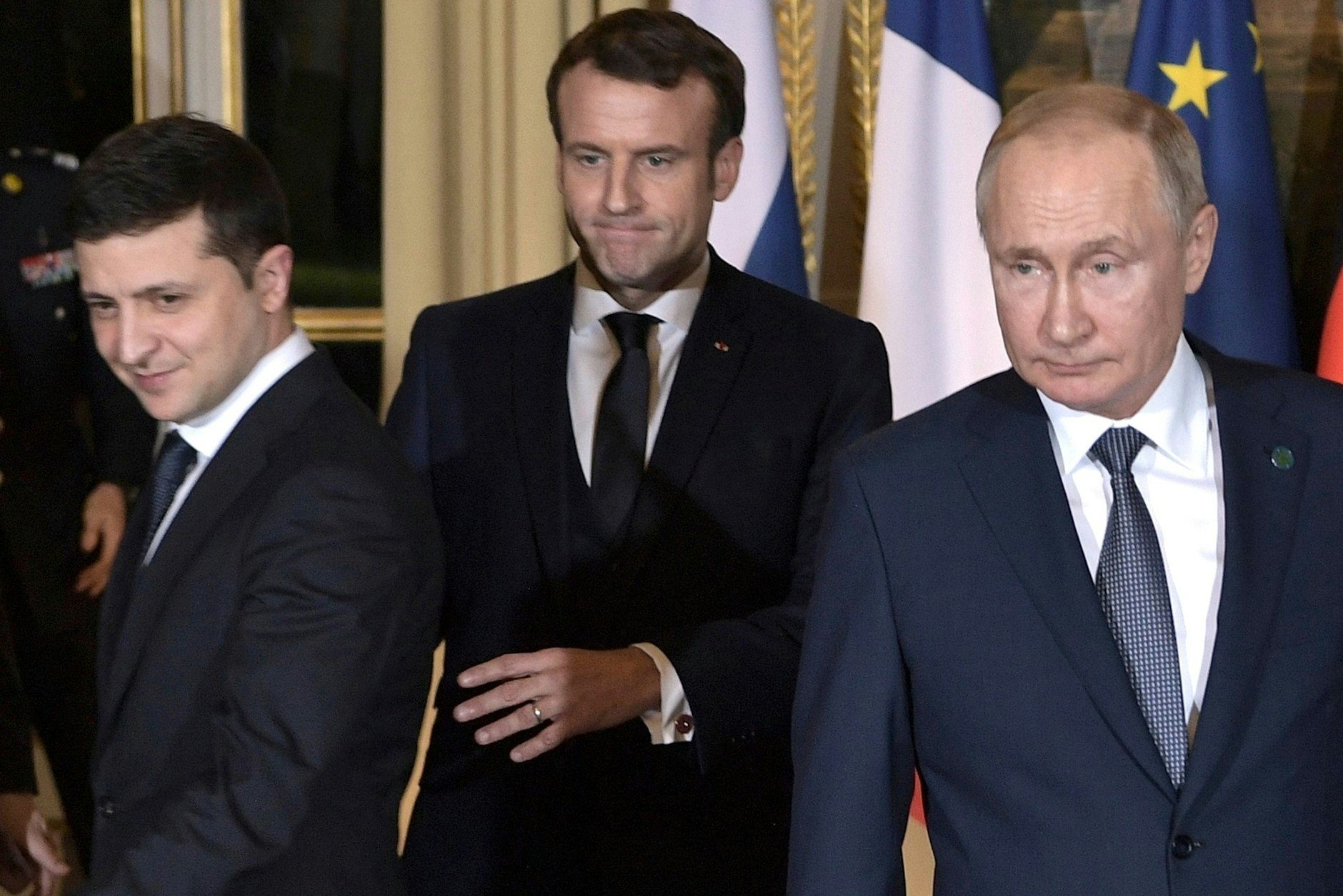 Emmanuel Macron (M), Präsident von Frankreich, geleitet Wolodymyr Selenskyj (l), Präsident der Ukraine, und Wladimir Putin, Präsident von Russland, zu ihren Plätzen für ein gemeinsames Gespräch mit Bundeskanzlerin Merkel im Pariser Schloss Elysee, am 09.12.2019. Deutschland zählt laut dem geleakten Entwurf von 2022 nicht mehr zu den Garantie-Mächten für einen Frieden in der Ukraine.&nbsp;