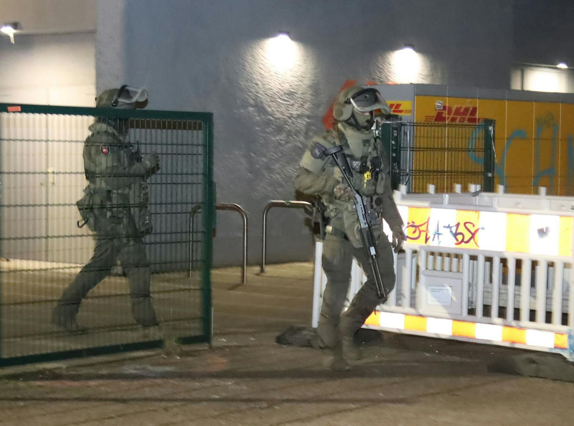 Polizisten in Spezialausrüstung verlassen ein Hochhaus in Berlin-Friedrichshain.