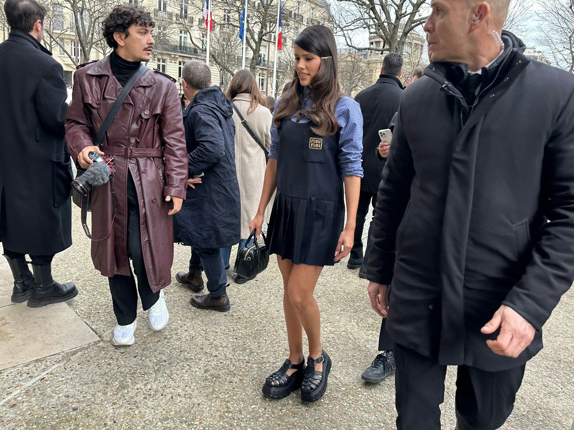 Auch wenn es ein bisschen kalt ist, der Frühling kommt bestimmt. Das Outfit wird jedenfalls schon einmal probegetragen: Karierte Bluse, Minikleid, Arcadie-Täschchen und Plateau-Sandalen, alles Miu Miu.