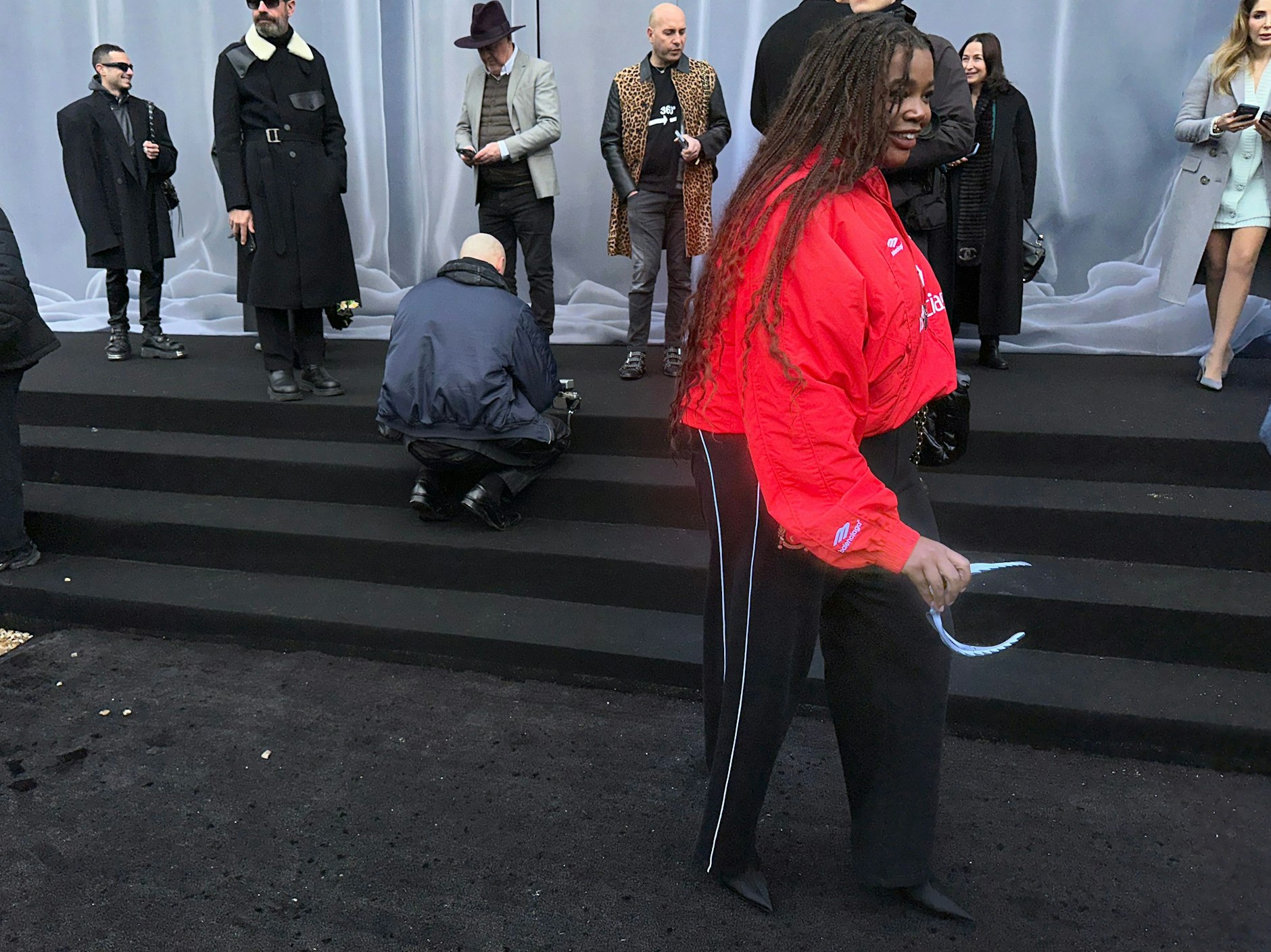 Die schlecht gelaunte Kim Kardashian ist schon durch; die Dame in roter Balenciaga-Sportkleidung verbreitet zum Glück deutlich bessere Stimmung.&nbsp;