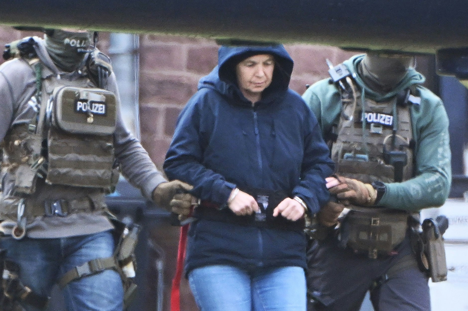 Im Innenhof eines Behördenzentrums in Karlsruhe wird die frühere RAF-Terroristin Daniela Klette zu einem Hubschrauber geführt. Zuvor hatte sie einen Haftprüfungstermin beim Bundesgerichtshof (BGH). 