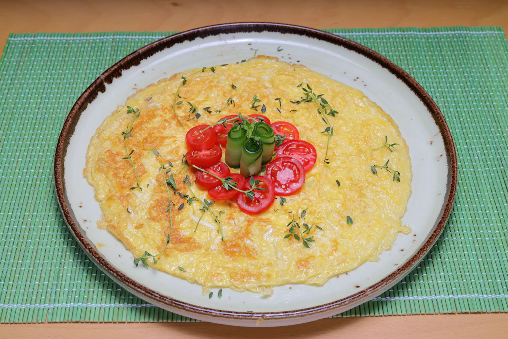 Eier goldgelb aus der Pfanne: Rezept für ein einfaches Käse-Kräuter-Omelett