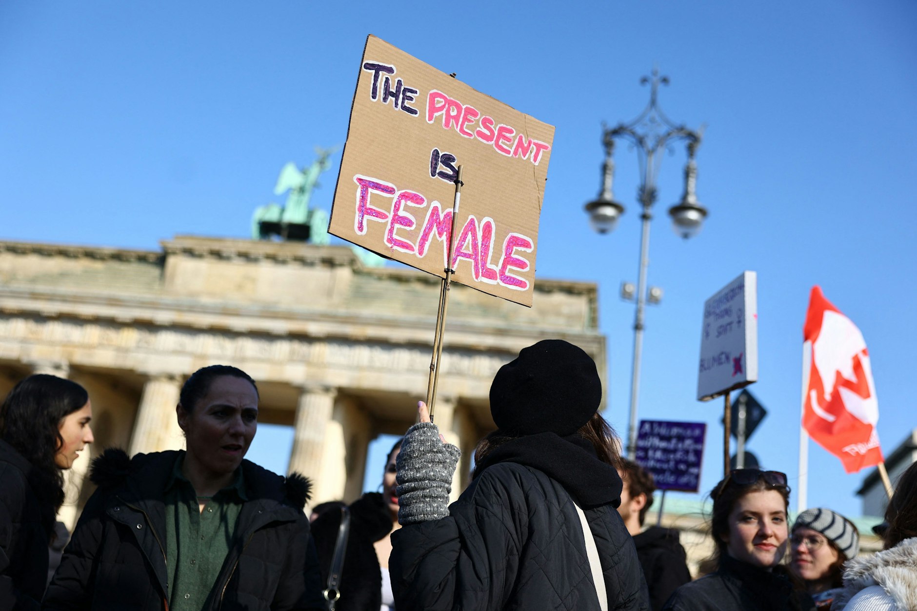 Menschen demonstrieren am Internationalen Frauentag am Brandenburger Tor in Mitte, für bessere Lebens- und Arbeitsbedingungen für Frauen.