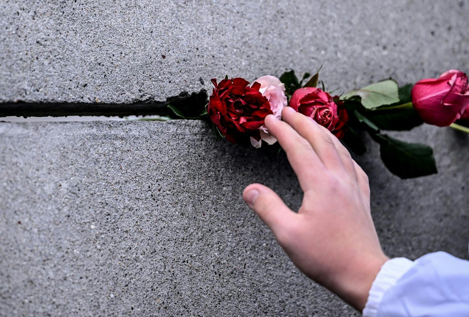 ARCHIV - Schüler stecken bei der Zentralen Gedenkveranstaltung des 34. Jahrestags des Mauerfalls.