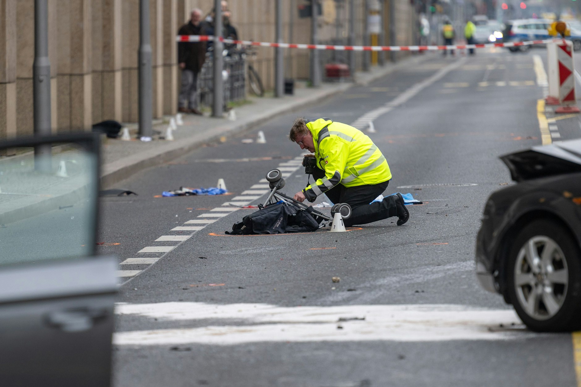 Ein erschütternder Anblick: Ein Polizist kniet an der Unfallstelle auf der Leipziger Straße an einem Kinderwagen.