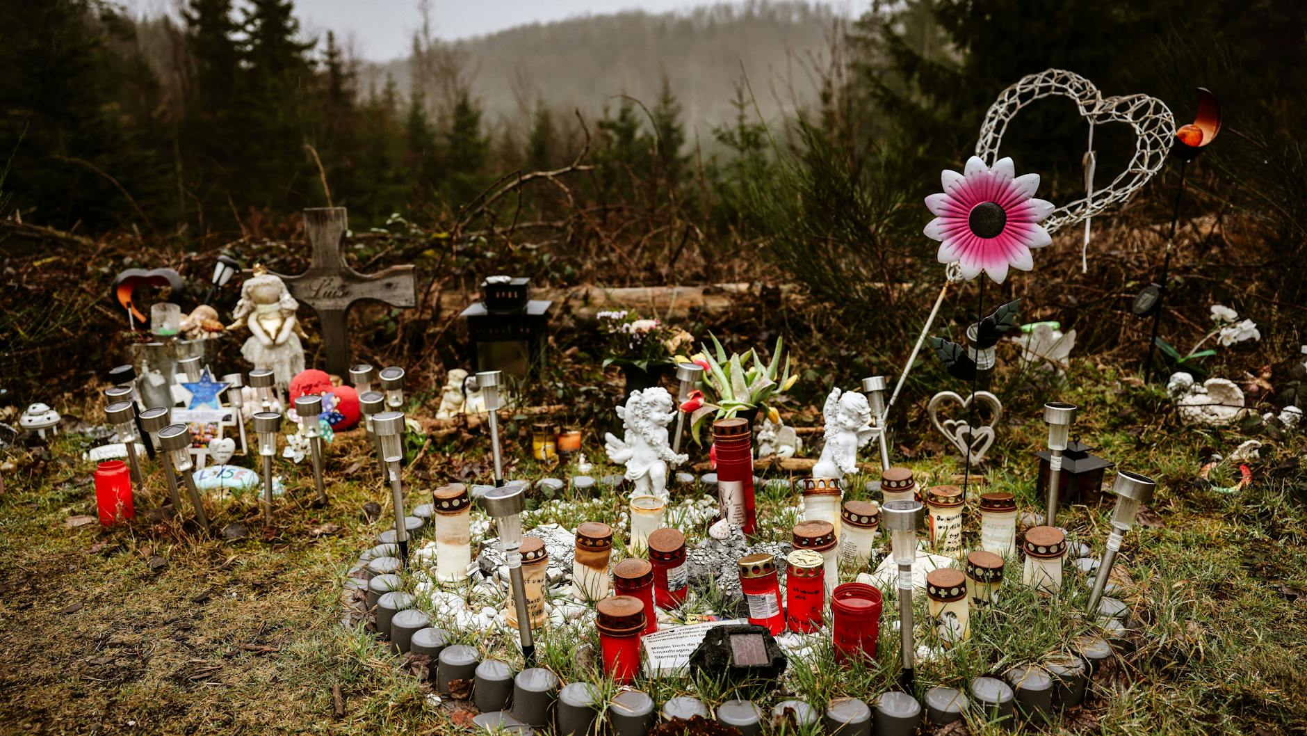 Kerzen, Blumen und Figuren liegen am Fundort an der Landesgrenze zwischen Rheinland-Pfalz und Nordrhein-Westfalen. Die zwölf Jahre alte Schülerin Luise war im März 2023 erstochen worden.