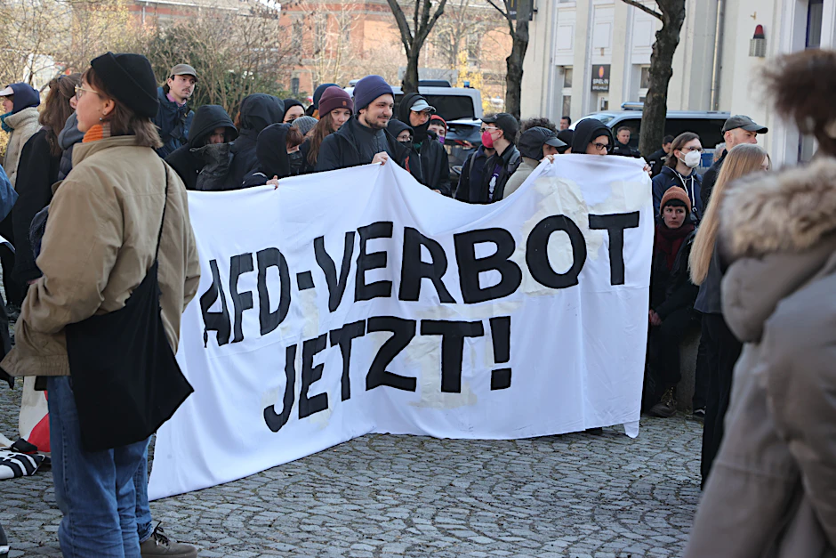 "AfD-Verbot jetzt" steht auf einem Banner bei einer linken Demonstration gegen ein rechtes Protestcamp. 