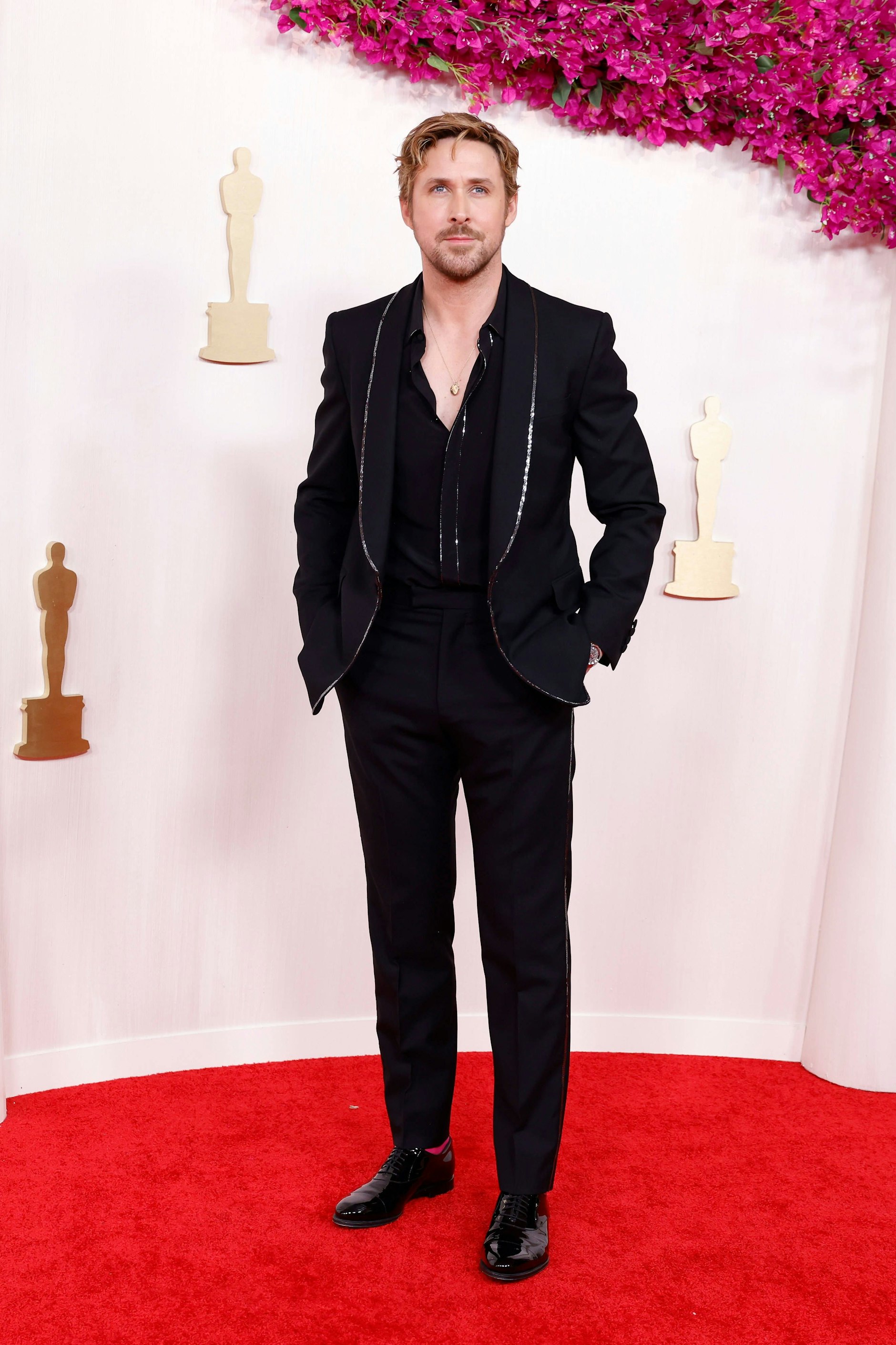 <strong>TOP:</strong> Für seinen großen musikalischen Auftritt von „I’m just Ken“ bei den Oscars&nbsp;– wo <strong>Ryan Gosling</strong> mit 65 weiteren Kens einen Marilyn-Monroe-Moment hinlegte, kleidete er sich komplett in Pink. Für den roten Teppich wählte der Schauspieler einen weniger an „Barbie“ erinnernden Moment. Klassisch-cool-modern kam sein schwarzer Gucci-Anzug daher. Die silbernen Ziernähte auf seinem Jackett und dem aufgeknöpften Hemd unterstrichen seine stahlblauen Augen, ein toller Hingucker. Ganz ohne „Barbie“-Hommage ging es dann aber nicht, seine Socken blitzten im kräftigen Pink hervor.
