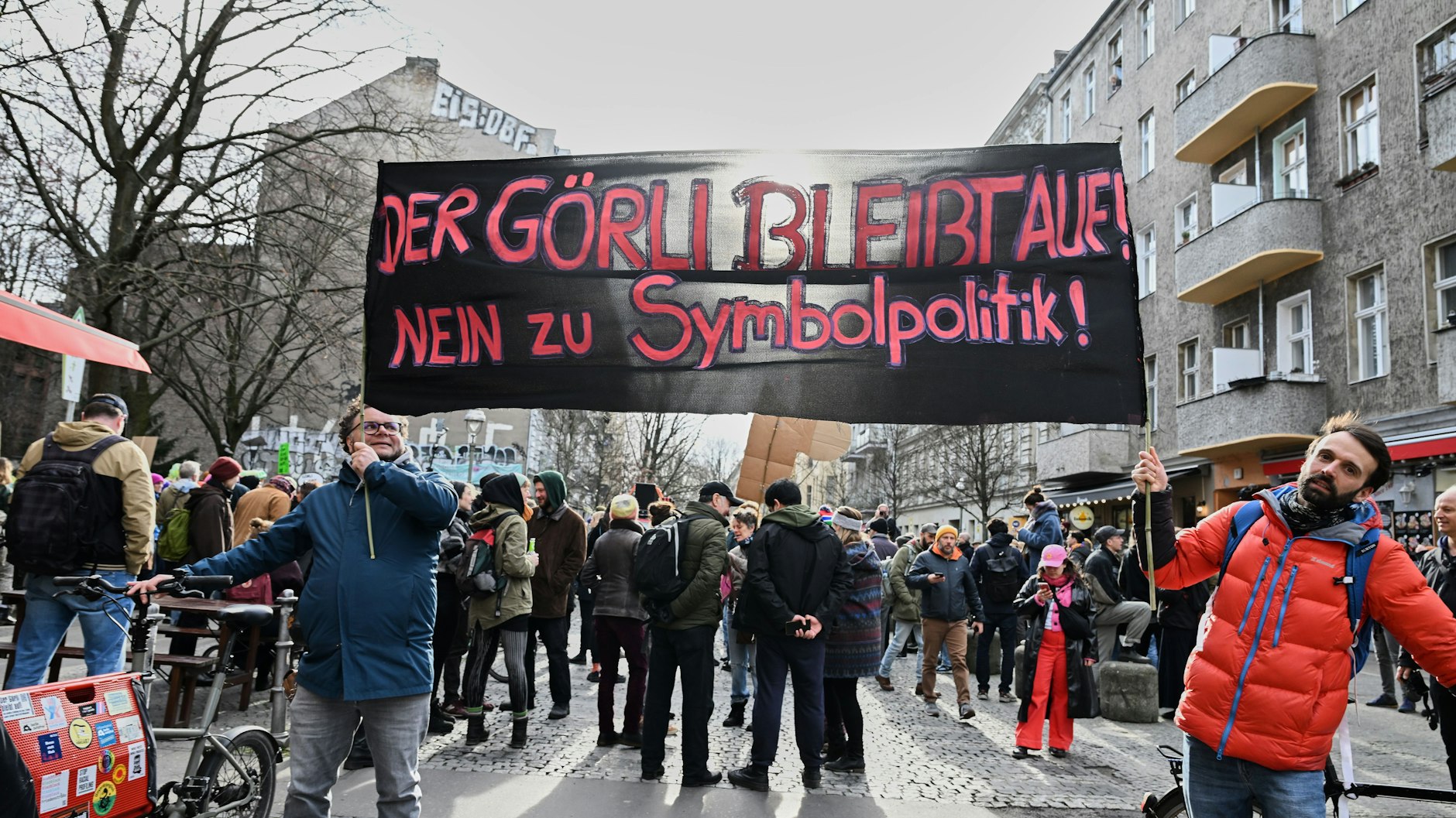 „Der Görli bleibt auf! Nein zu Symbolpolitik!“ steht auf dem Banner, das die Teilnehmer einer Demonstration gegen eine Umzäunung und nächtliche Schließung des Görlitzer Parks zeigen. 