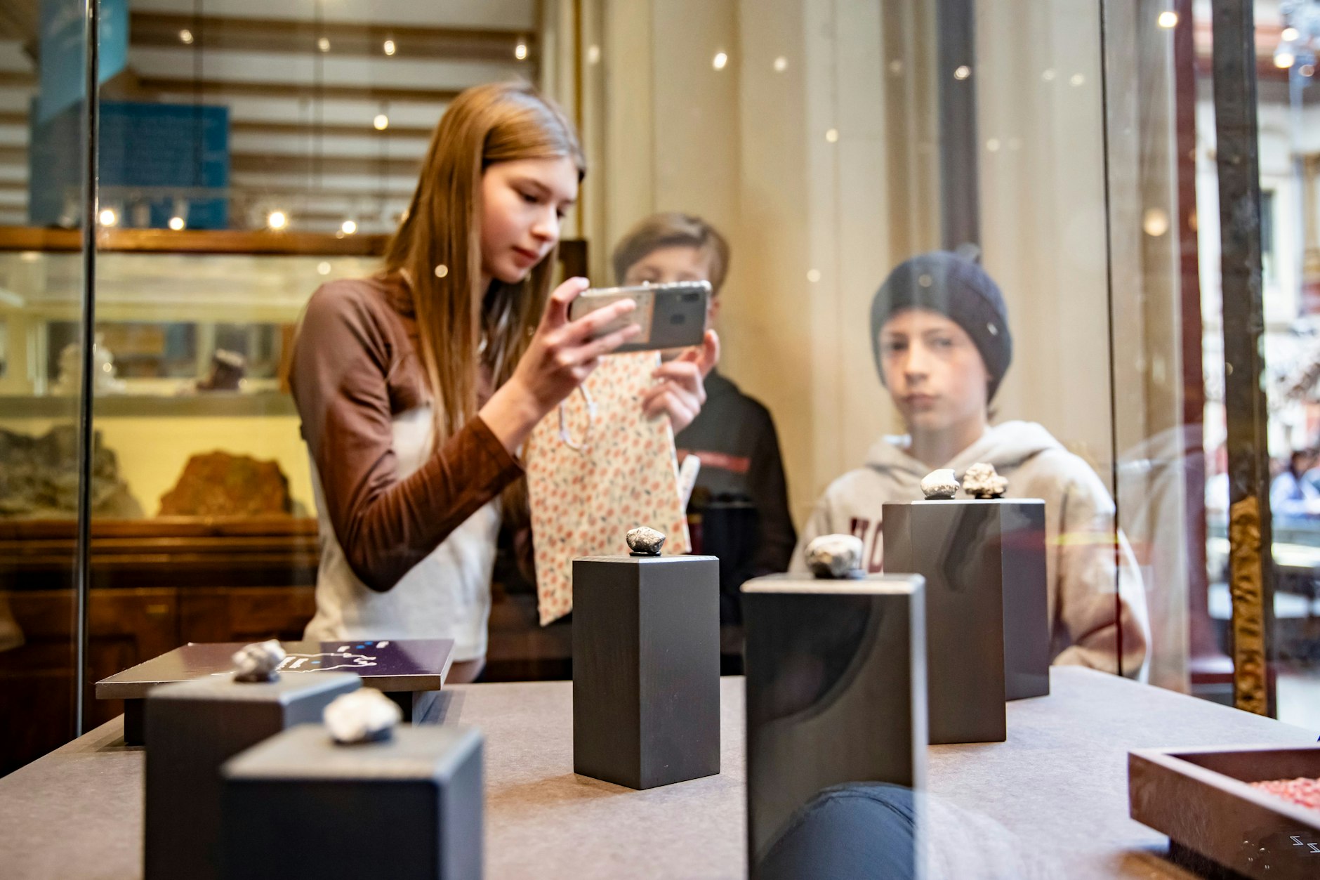 Kinder schauen die Vitrine mit Meteoriten aus Brandenburg im Naturkundemuseum in Berlin an. 