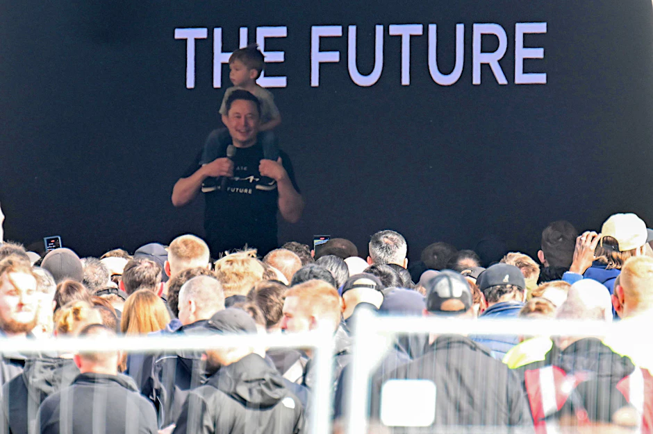 Tesla-Chef Elon Musk spricht in der Tesla-Gigafactory Berlin-Brandenburg zu den Mitarbeitern und trägt dabei ein Kind auf den Schultern.&nbsp;&nbsp;