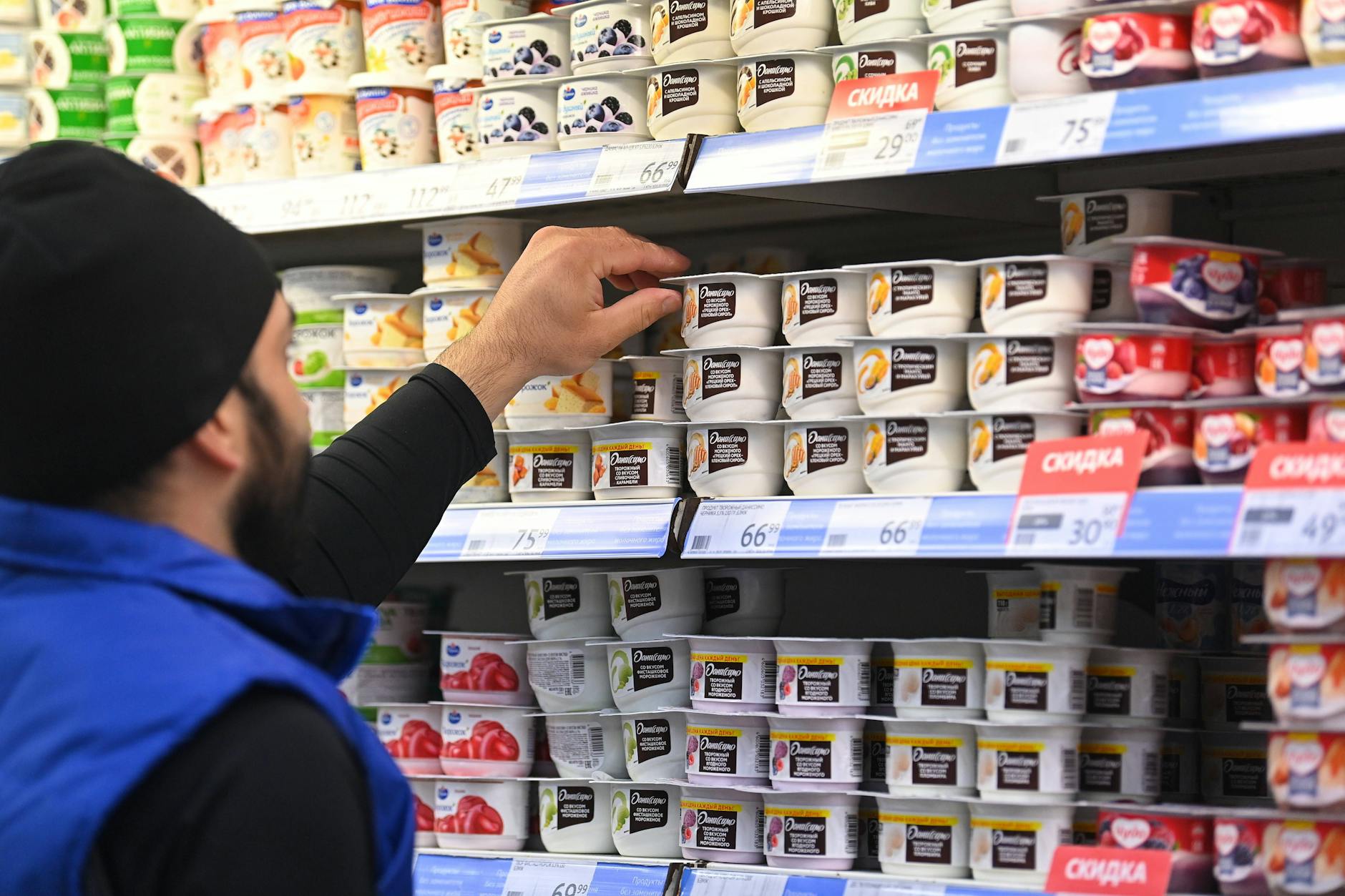 Ein Mitarbeiter eines russischen Lebensmittelgeschäfts in Moskau sortiert Milchprodukte von Danone in die Regale.