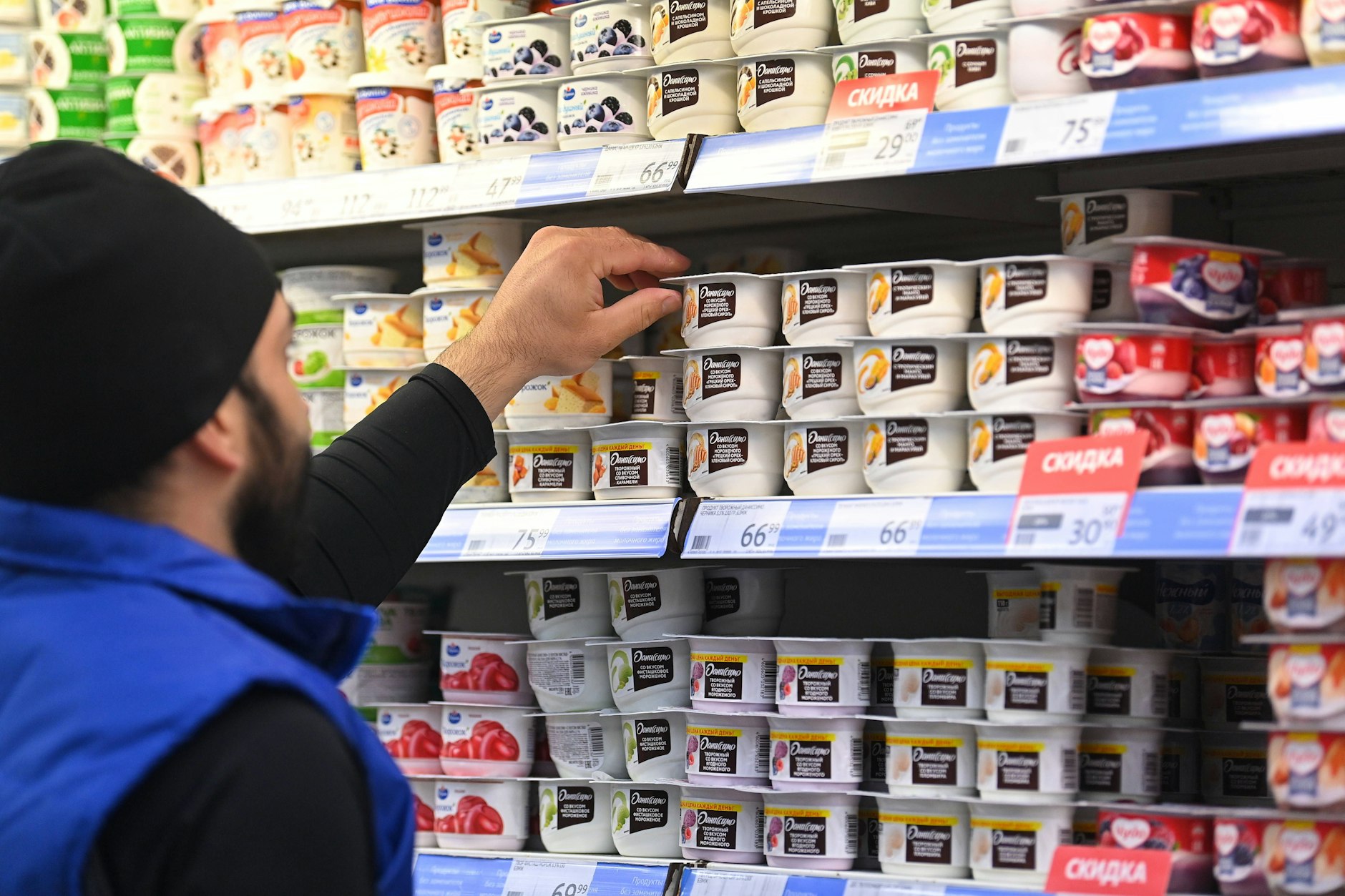 Ein Mitarbeiter eines russischen Lebensmittelgeschäfts in Moskau sortiert Milchprodukte von Danone in die Regale.