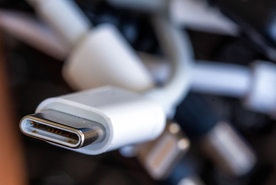 Ein Ladekabel mit USB-C-Stecker liegt neben einem Bündel unterschiedlicher Anschlusskabel.