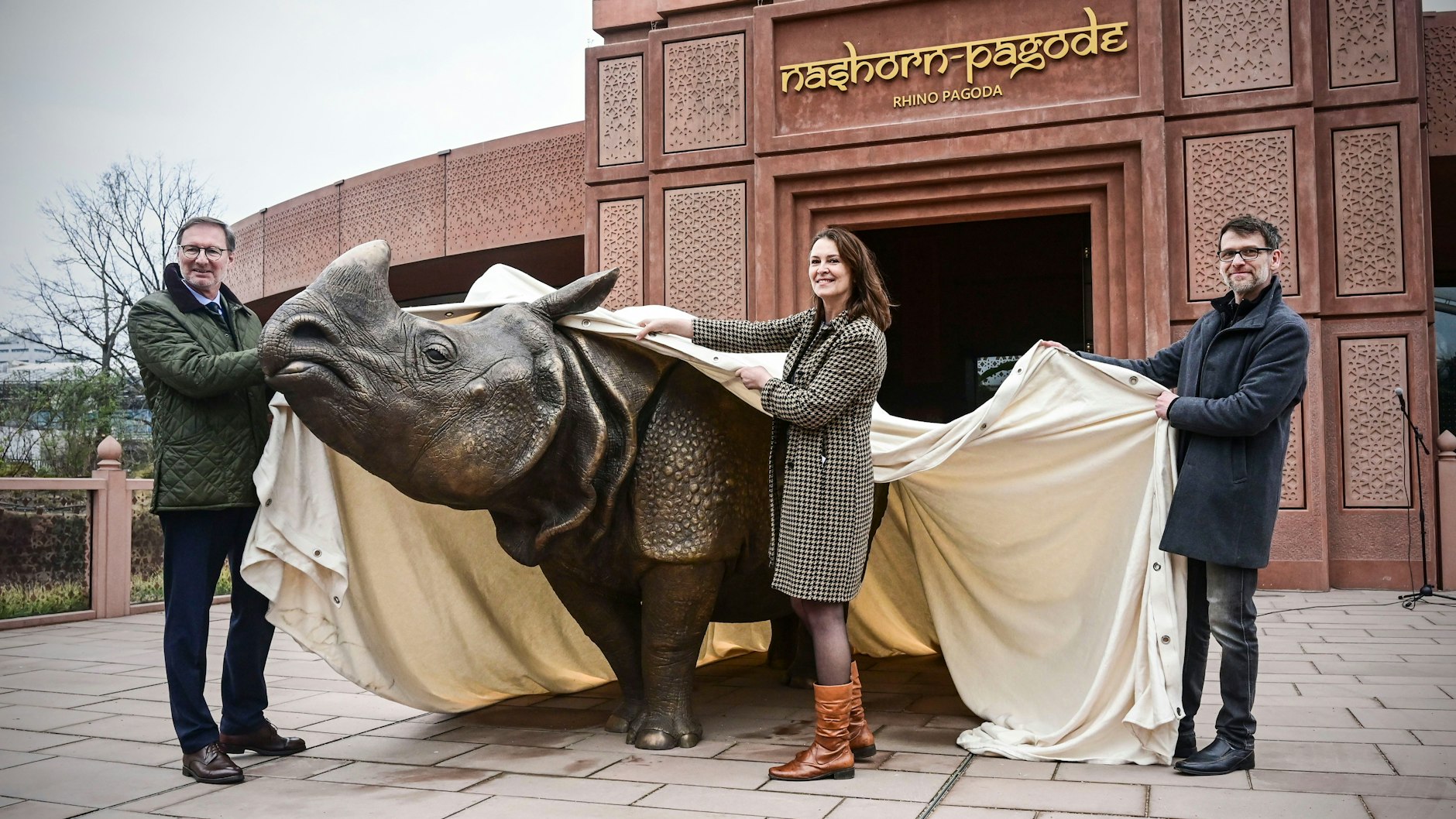 Zoo-Chef Andreas Knieriem enthüllt mit Kunstgießerei-Chefin&nbsp; Anke Schirlitz und Künstler Rico Rensmeyer die Nashorn-Skulptur im Berliner Zoo.