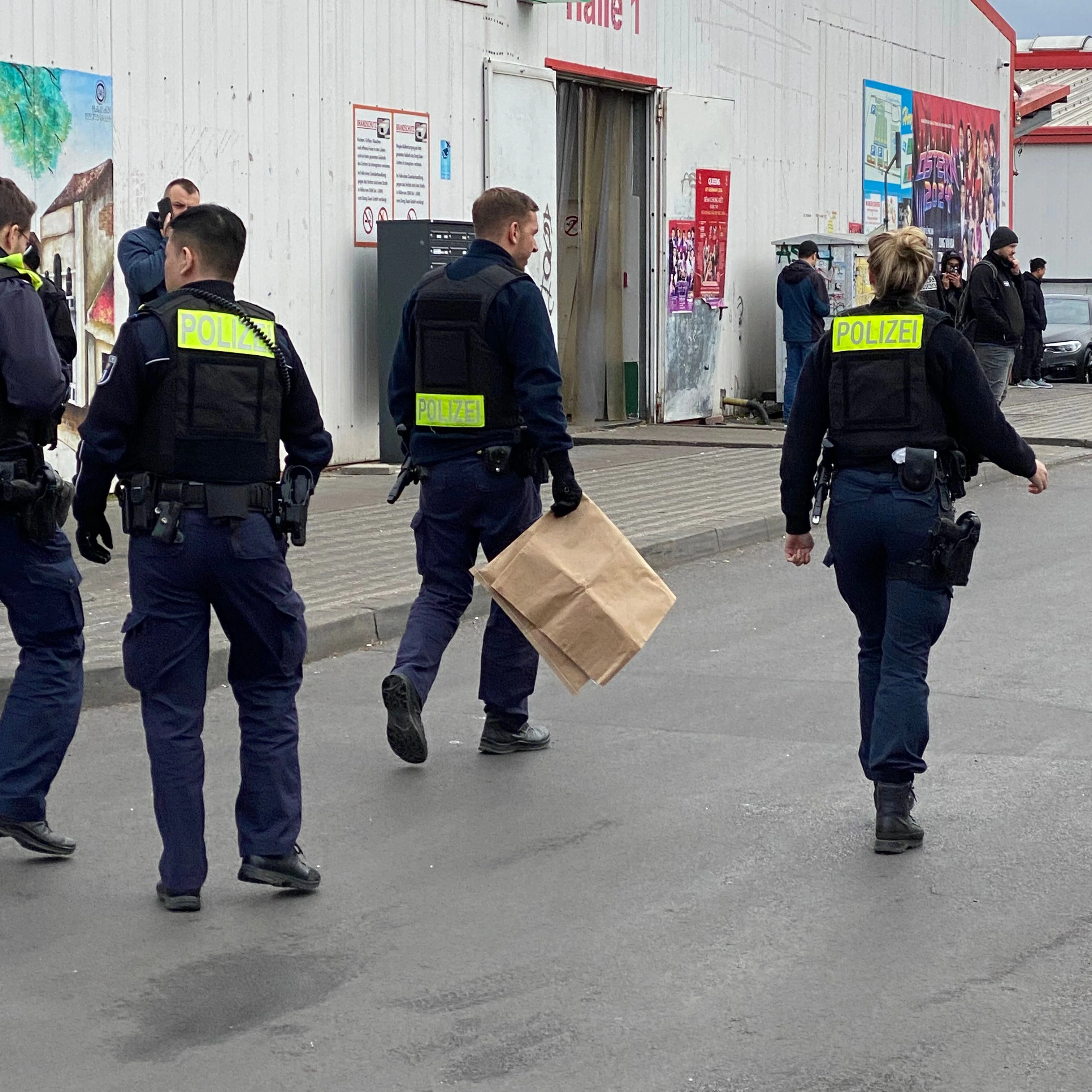 Polizisten am Samstagvormittag im Einsatz am Dong Xuan Center in Lichtenberg. In der Tüte soll sich das sichergestellte Messer befinden.