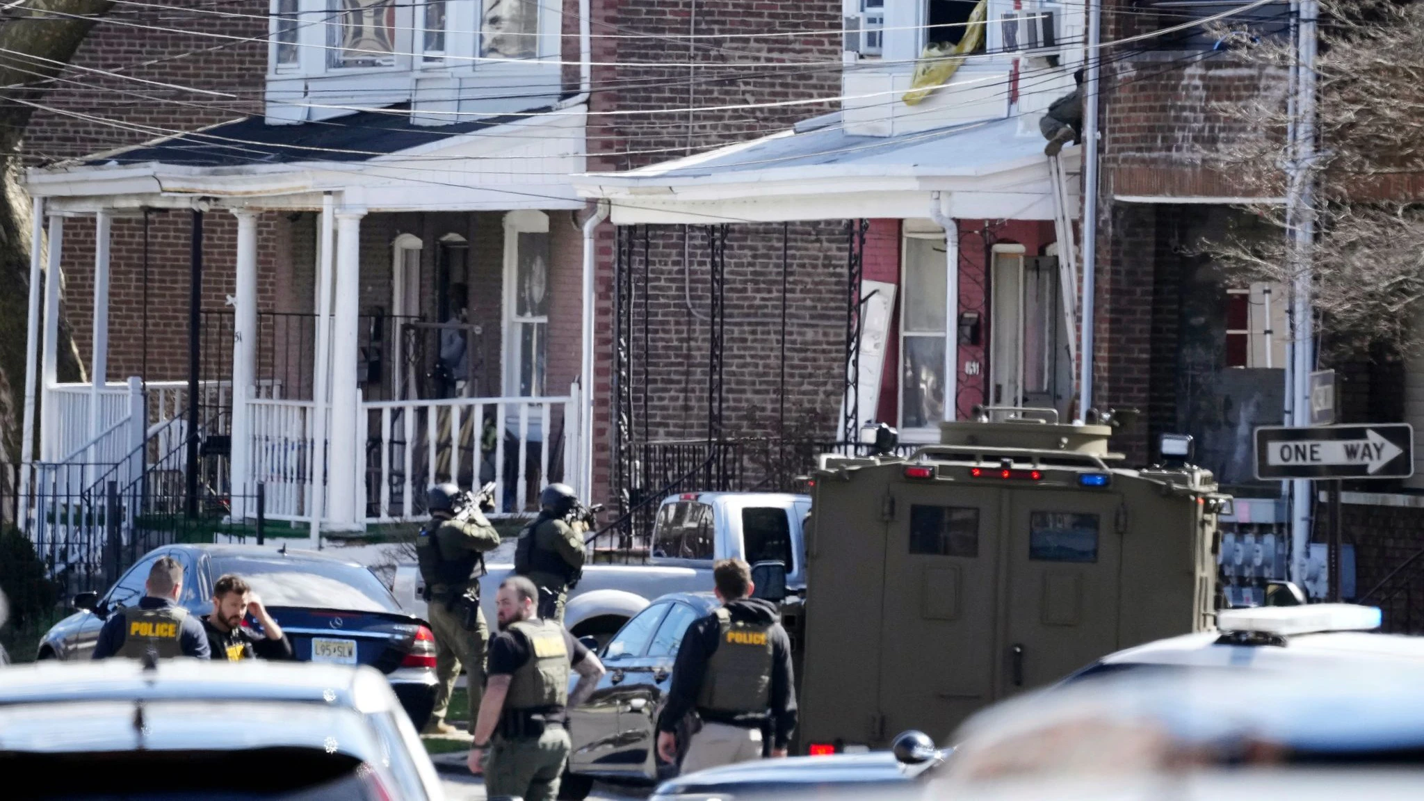 Polizisten umstellen das Haus in Trenton, in dem sich der mutmaßliche Täter mit seinen Geiseln verschanzt hat.  