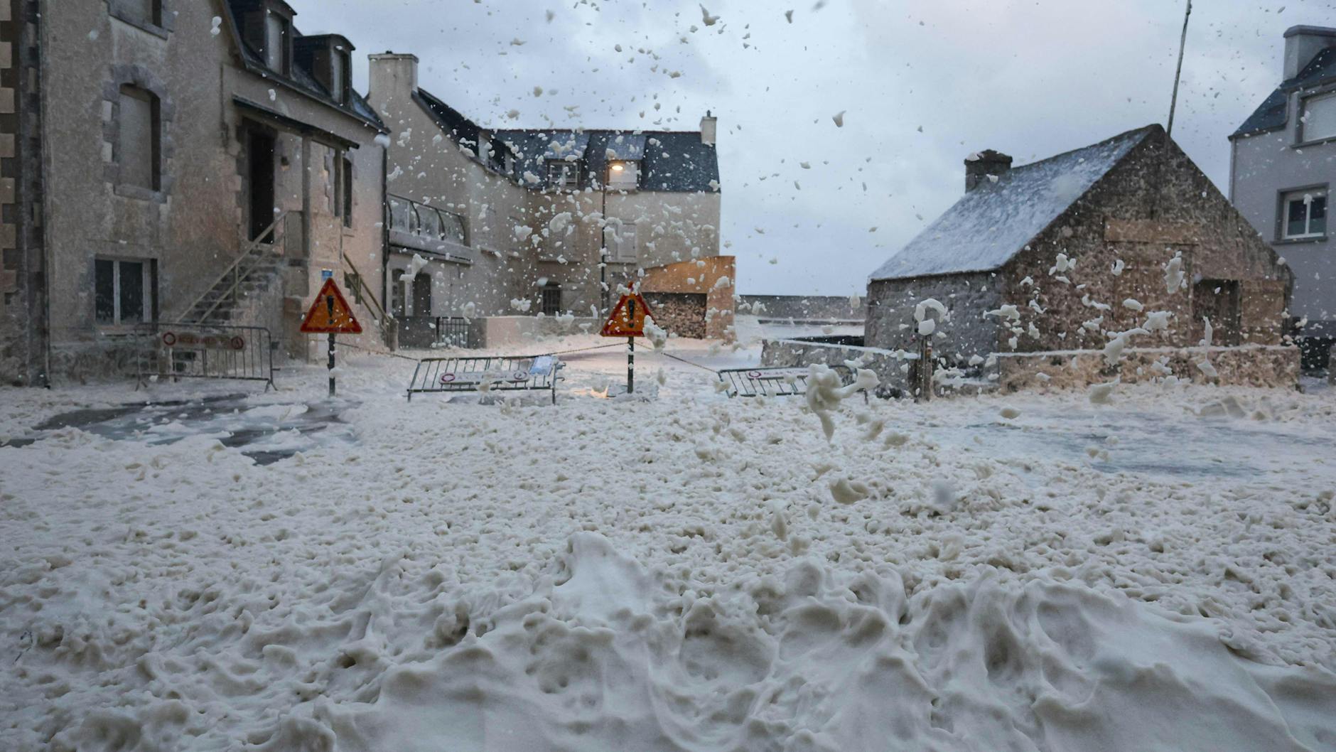 Schaum und Gischt fließen im November 2023 bei einem Unwetter über eine Straße im westfranzösischen Penmarc'h. 