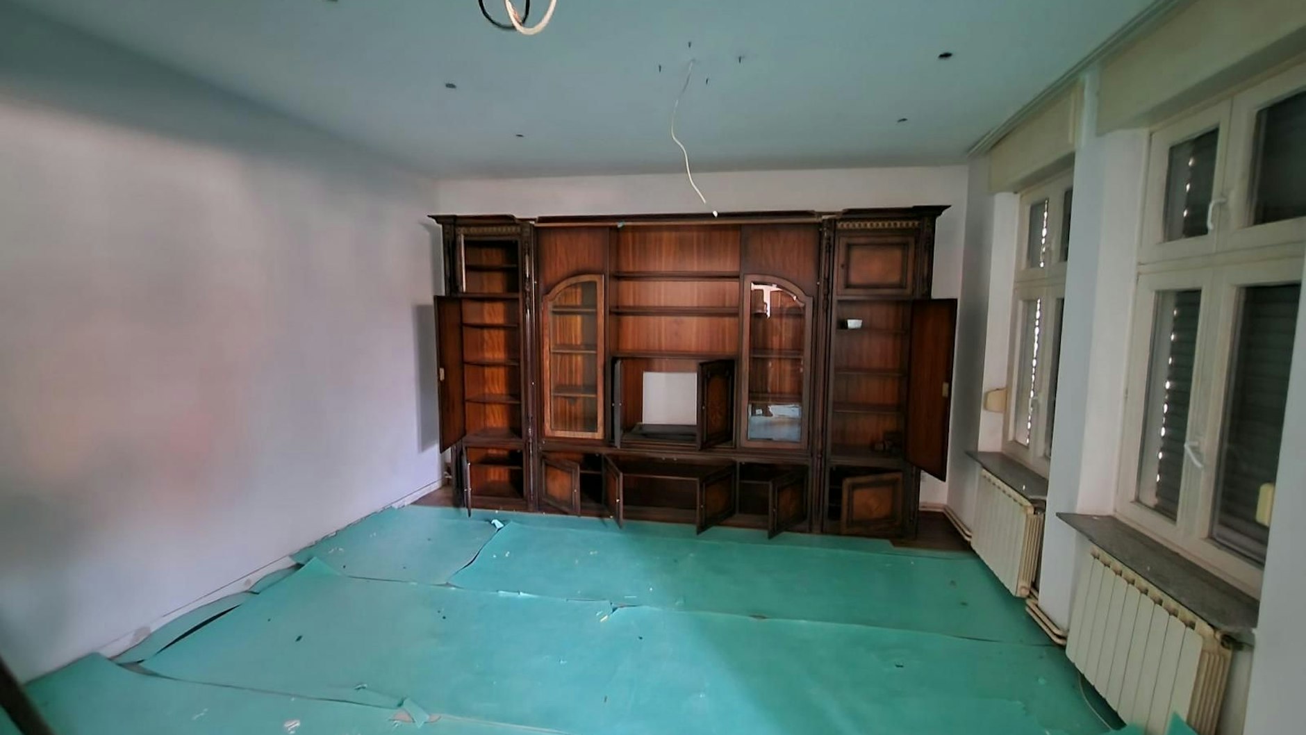 Ein weiteres leeres Zimmer der Clan-Villa: Ein Schrank steht noch da. Kabel hängen von der Decke.