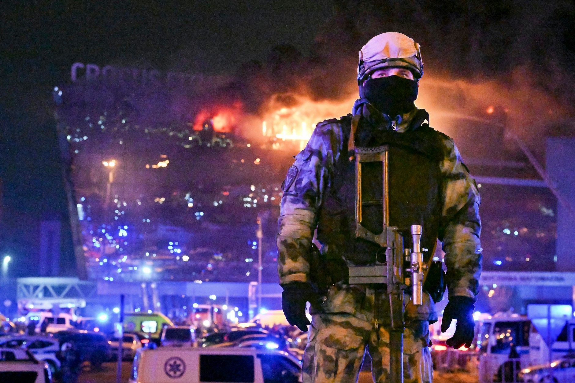 Ein Soldat der russischen Nationalgarde (Rosgwardija) sichert ein Gebiet, während über Crocus City Hall am westlichen Rand Moskaus ein gewaltiger Brand zu sehen ist. Bei dem Terroranschlag gab es viele Tote und Verletzte. 