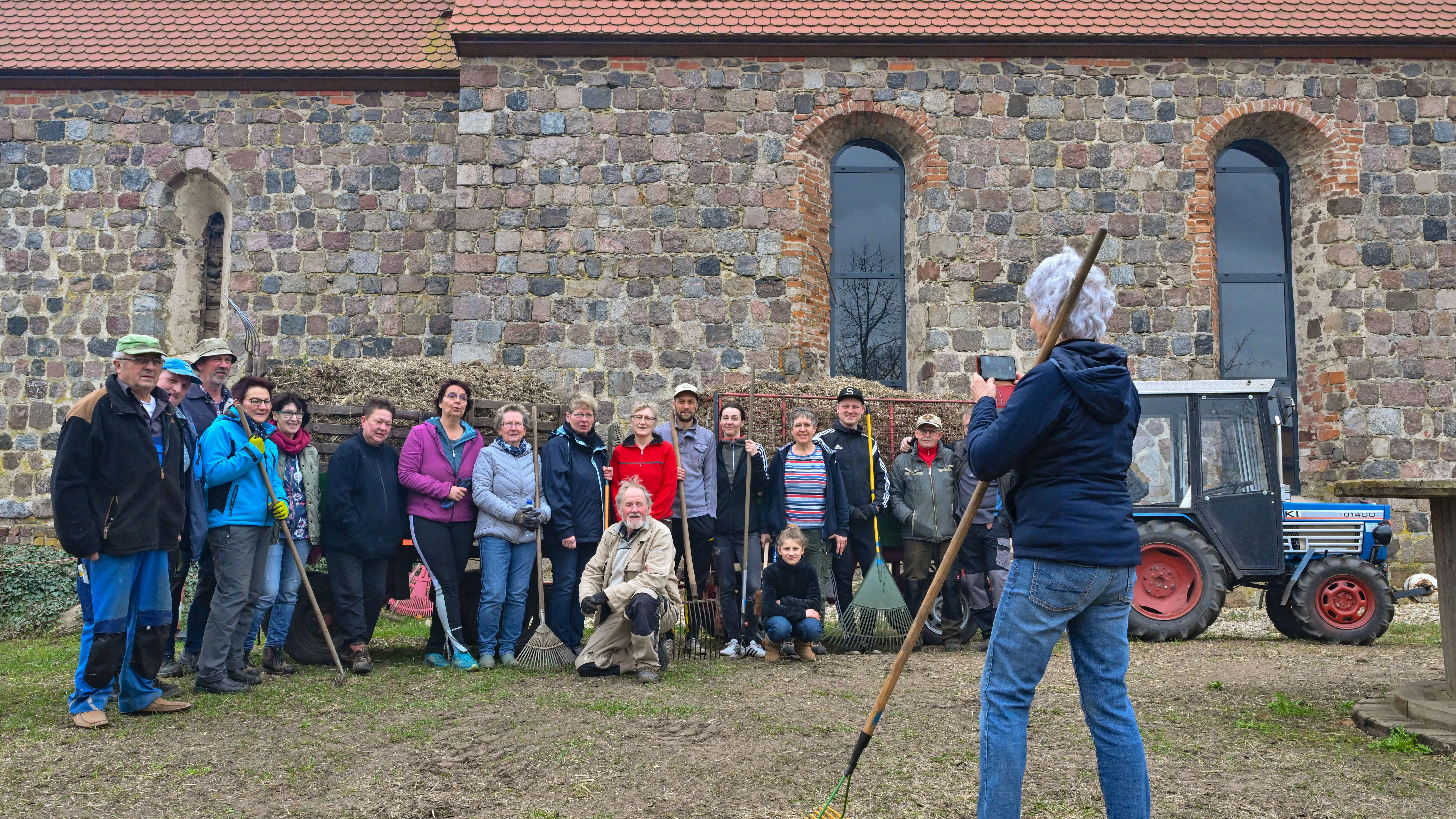 Einwohner von Dogelin machen ein Gruppenbild zum Abschluss des Frühjahrsputzes an ihrer Kirche. 