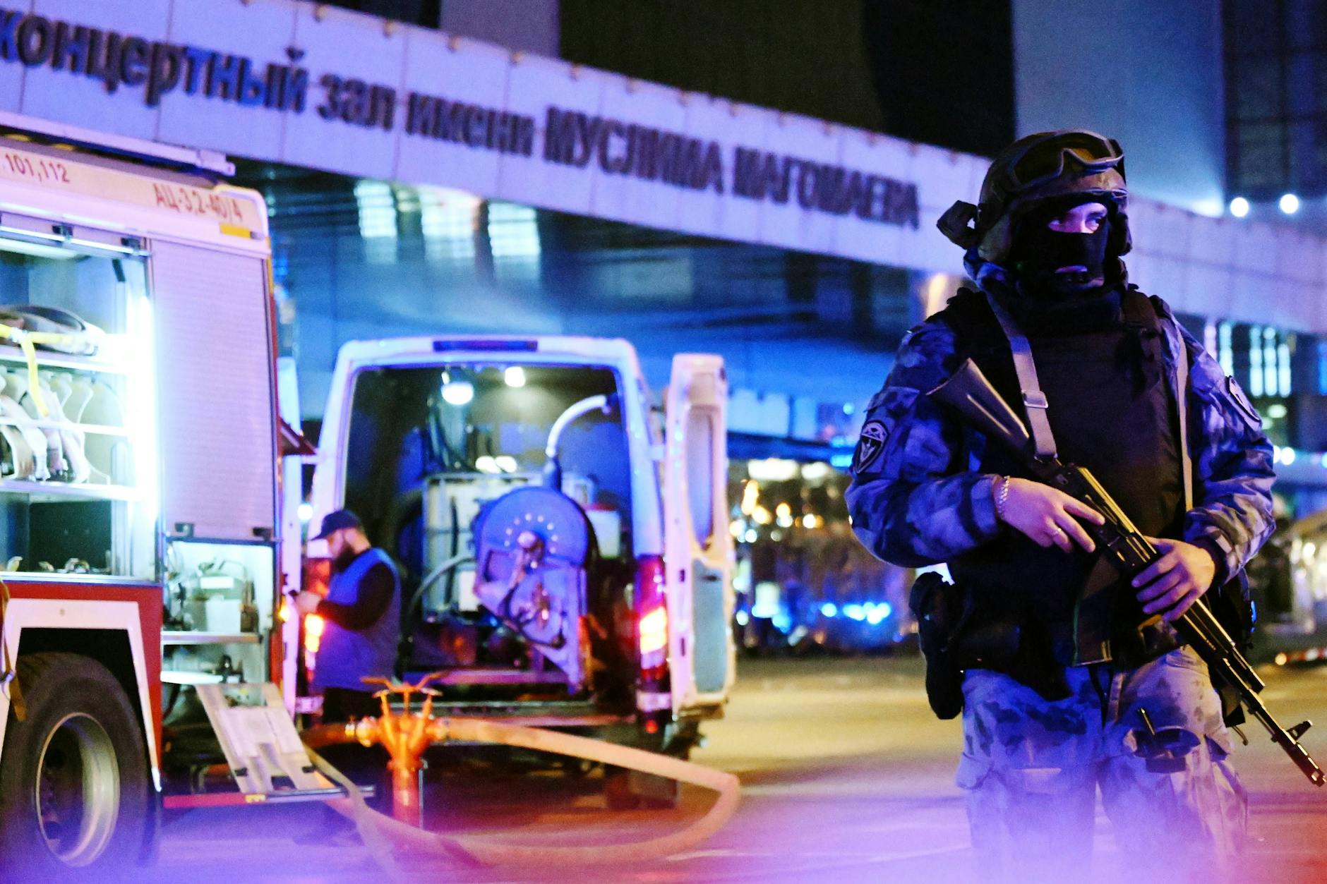 Vor der Konzerthalle stehen schwer bewaffnete Sicherheitskräfte und schützen Rettungsfahrzeuge.