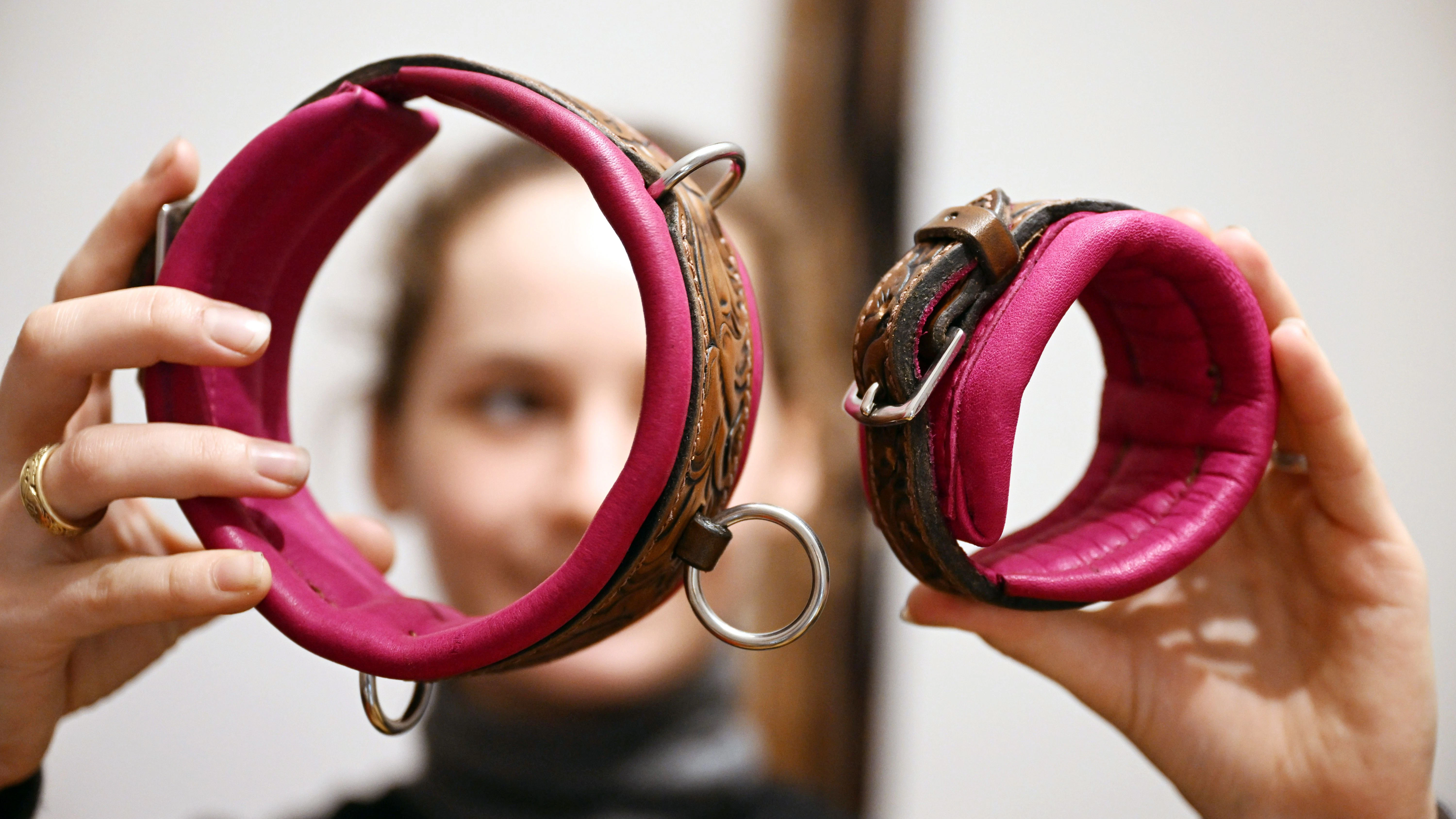 Viktoria Kottler zeigt in ihrer Werkstatt ein Halsband und eine Fessel aus Leder für den Erotikbereich.