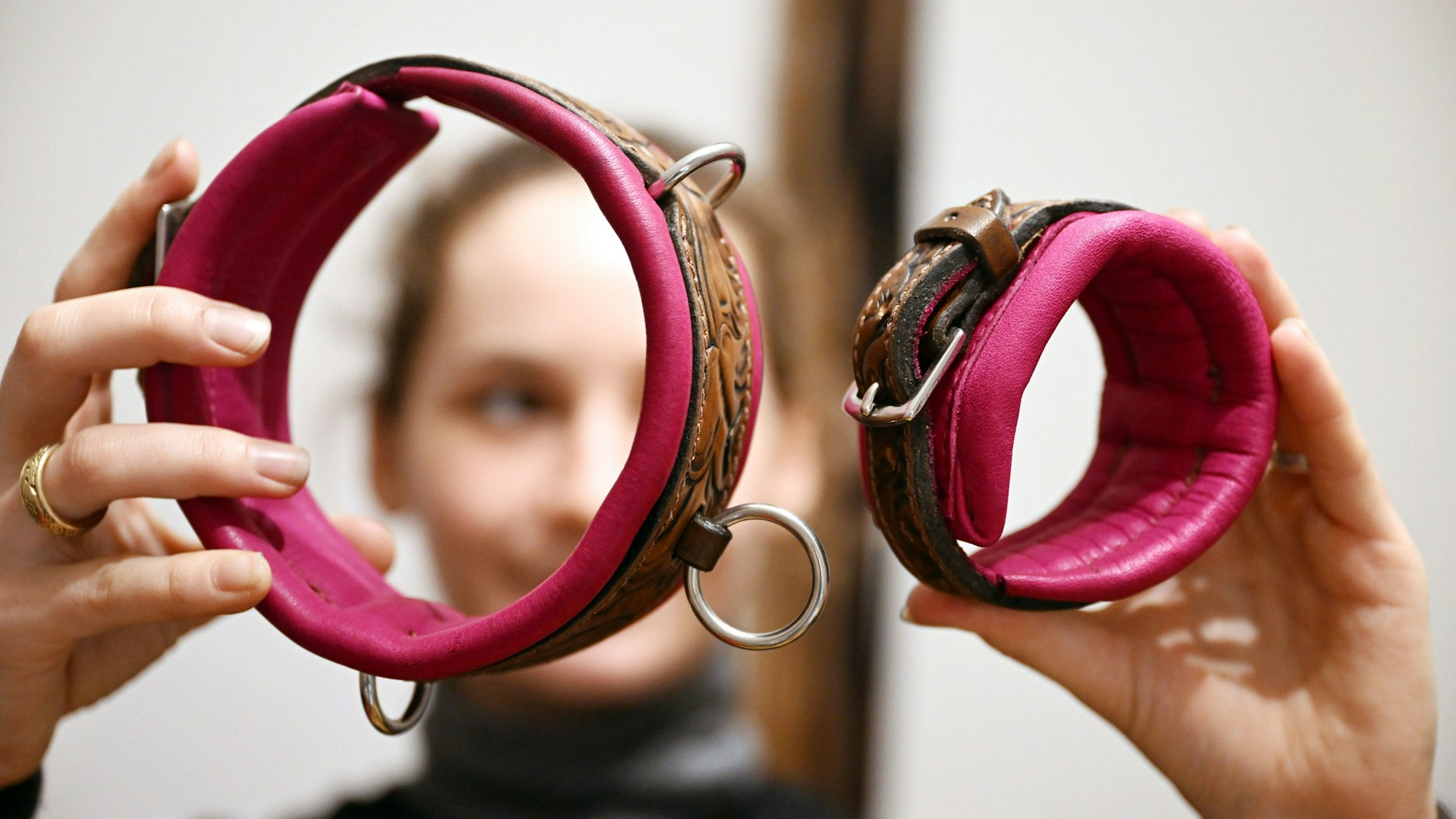 Viktoria Kottler zeigt in ihrer Werkstatt ein Halsband und eine Fessel aus Leder für den Erotikbereich.