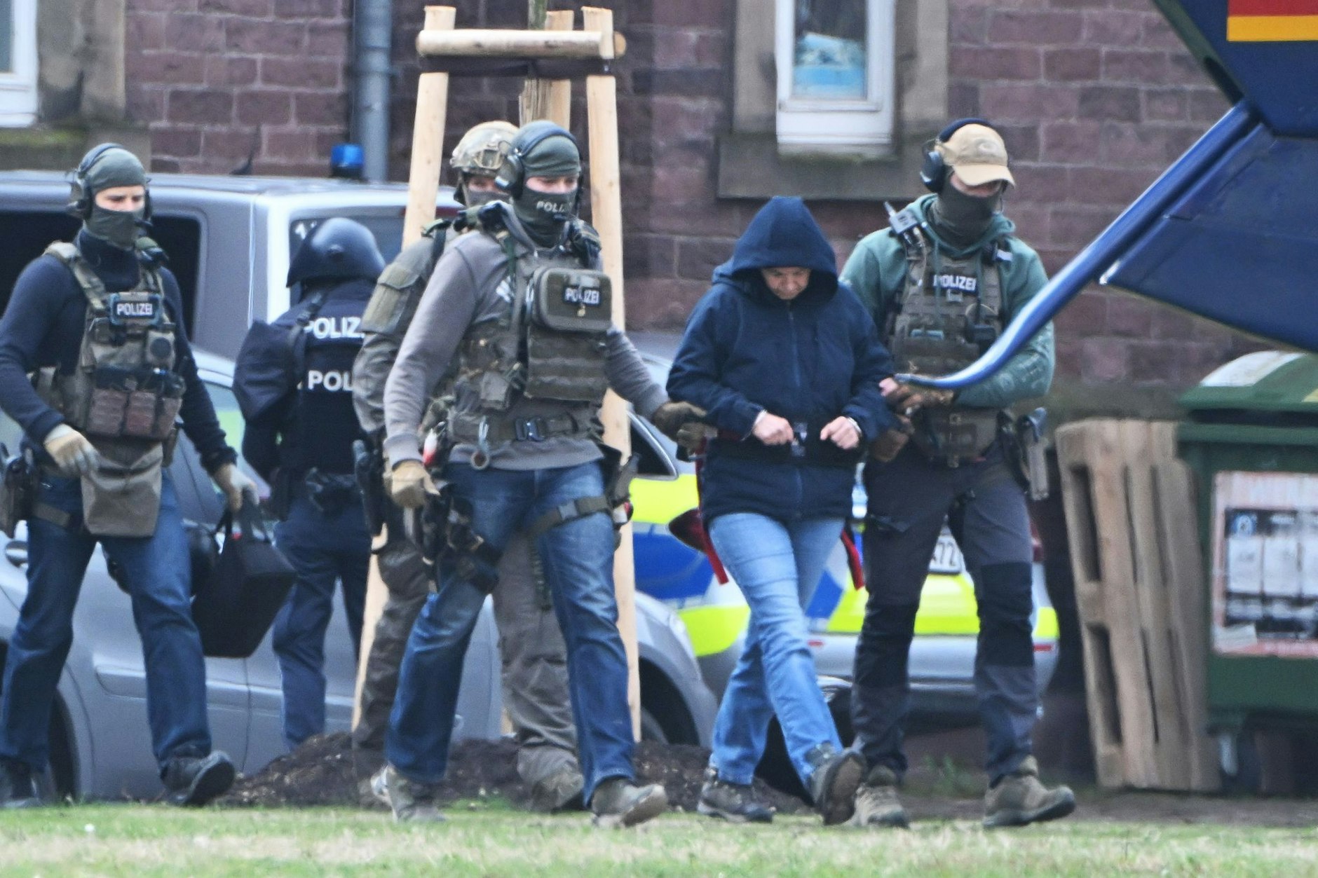 Die frühere RAF-Terroristin Daniela Klette wird nach einem Haftprüfungstermin beim Bundesgerichtshof von Polizisten zu einem Hubschrauber geführt. (Archivbild)