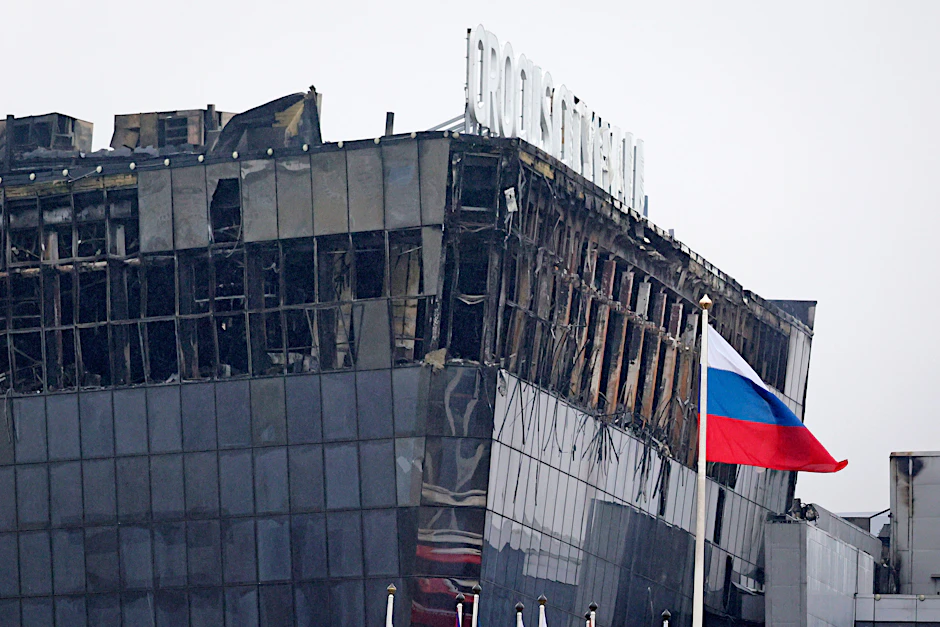 Ein Soldat der russischen Nationalgarde (Rosgwardija) sichert ein Gebiet, während über Crocus City Hall am westlichen Rand Moskaus ein gewaltiger Brand zu sehen ist. Bei dem Terroranschlag gab es viele Tote und Verletzte.&nbsp;