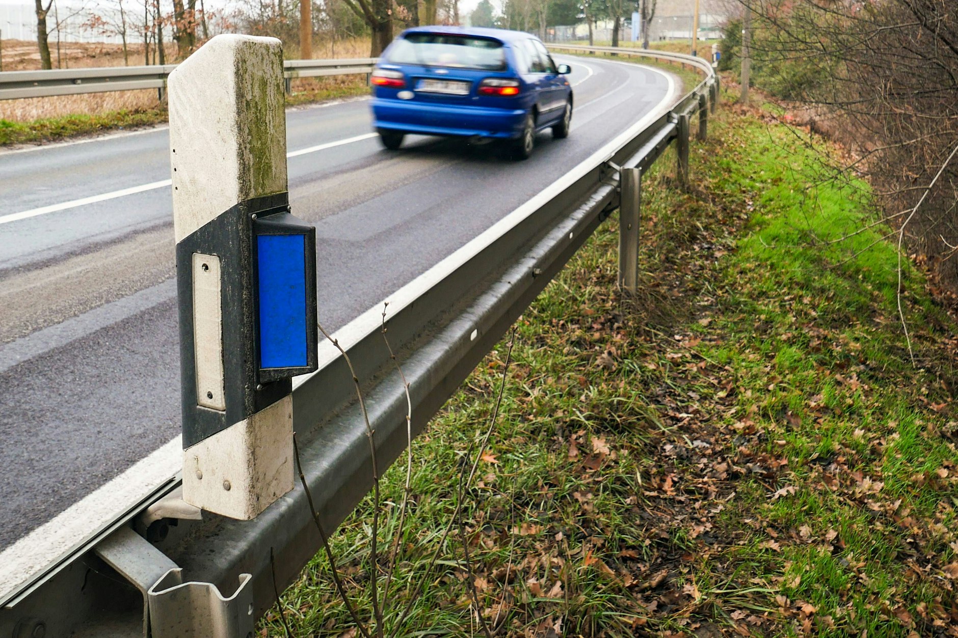 Jeder kennt die schwarz-weißen Straßenpfosten - aber warum haben manche einen blauen Reflektor an der Seite?