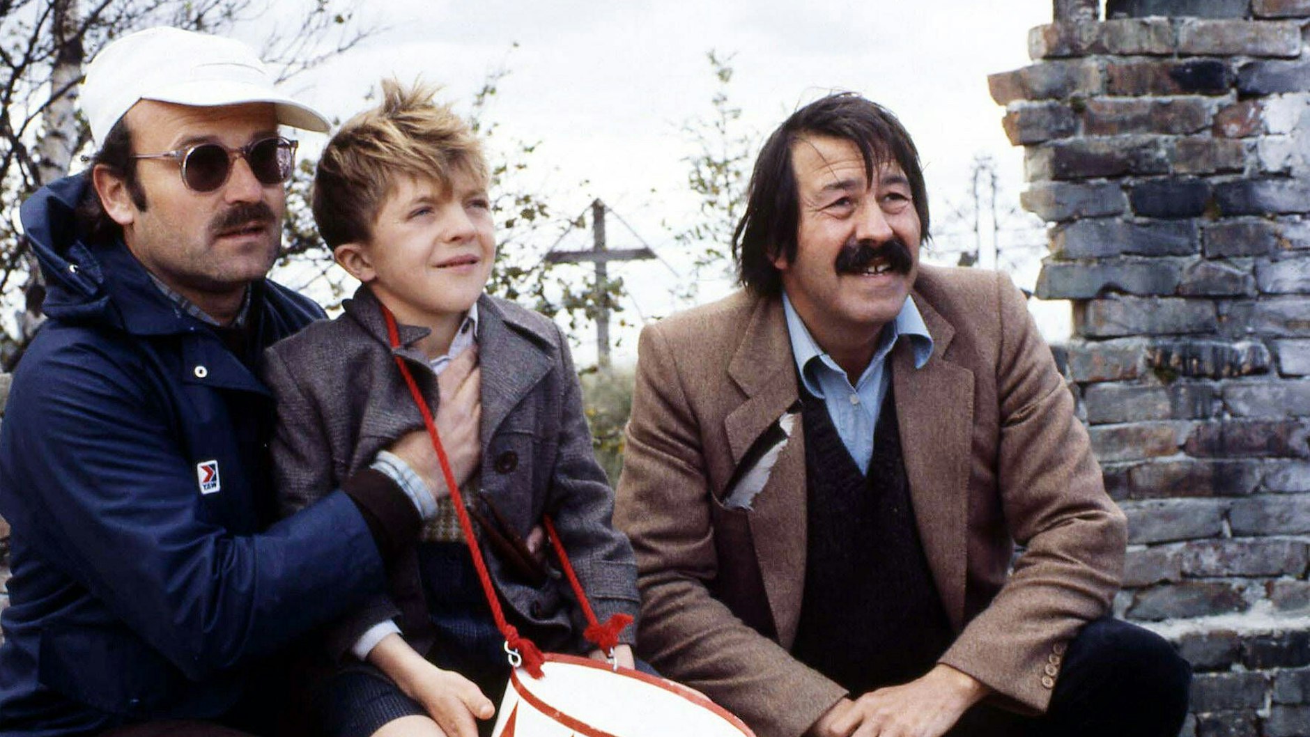 Volker Schlöndorff (l.), Darsteller David Bennent und Buchautor Günter Grass bei den Dreharbeiten zum Film „Die Blechtrommel“