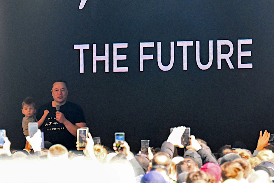 Tesla-Chef Elon Musk spricht in der Tesla-Gigafactory Berlin-Brandenburg zu den Mitarbeitern und hält dabei seinen Sohn auf dem Arm.