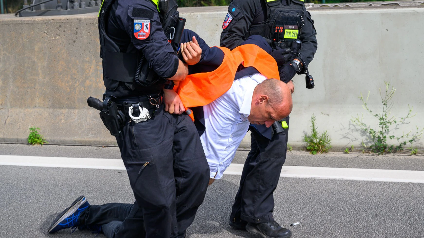 Wolfgang Metzler-Kick wird von Polizisten nach einer Autobahnblockade in Berlin weggeschleift.