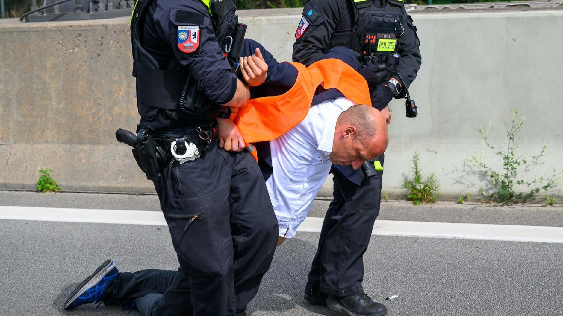 Wolfgang Metzler-Kick wird von Polizisten nach einer Autobahnblockade in Berlin weggeschleift.