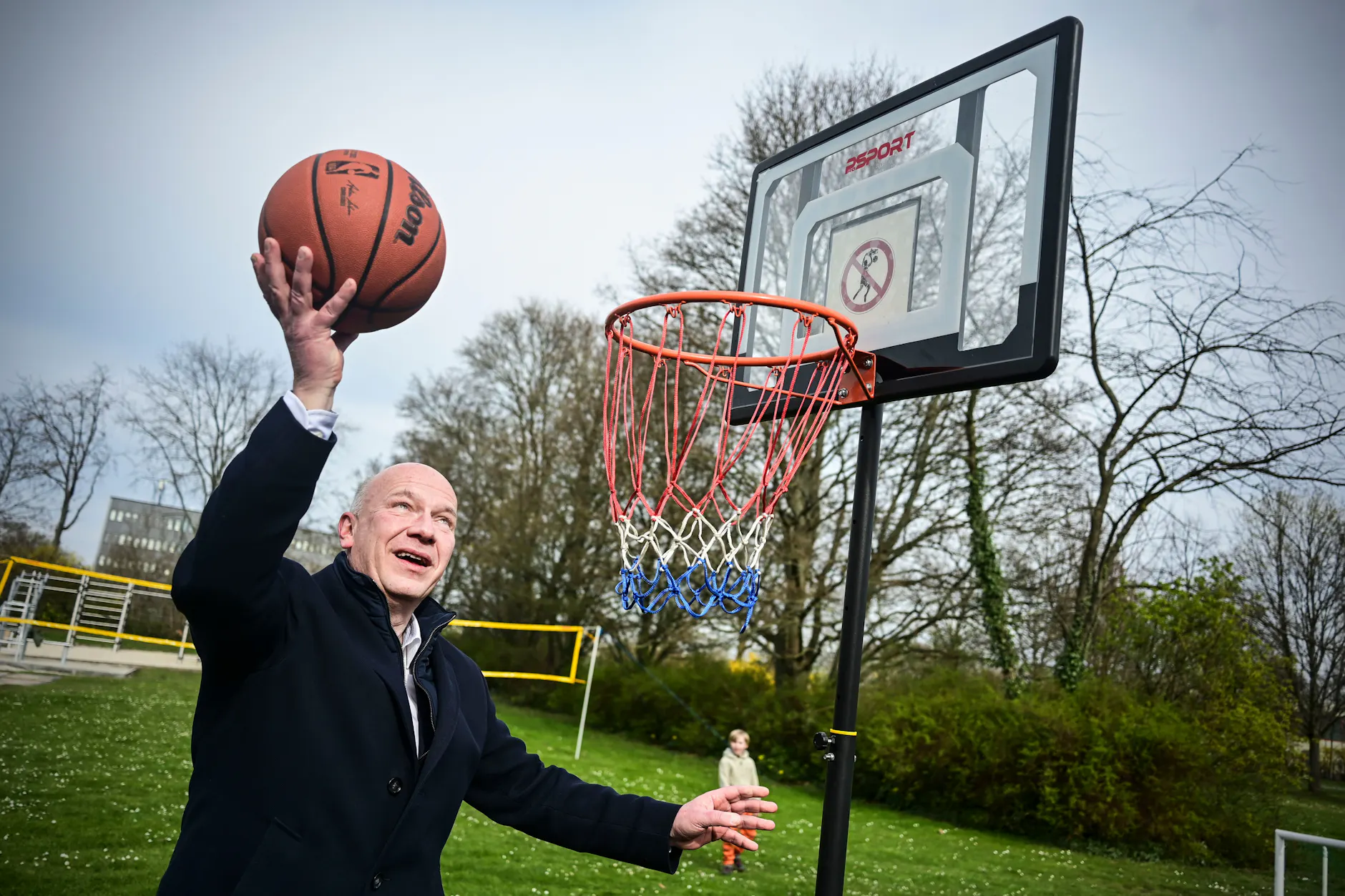 Der Regierende Bürgermeister Kai Wegner (CDU) versucht sich in Basketball während eines Besuchs einer neuen Sportfläche in Neukölln.