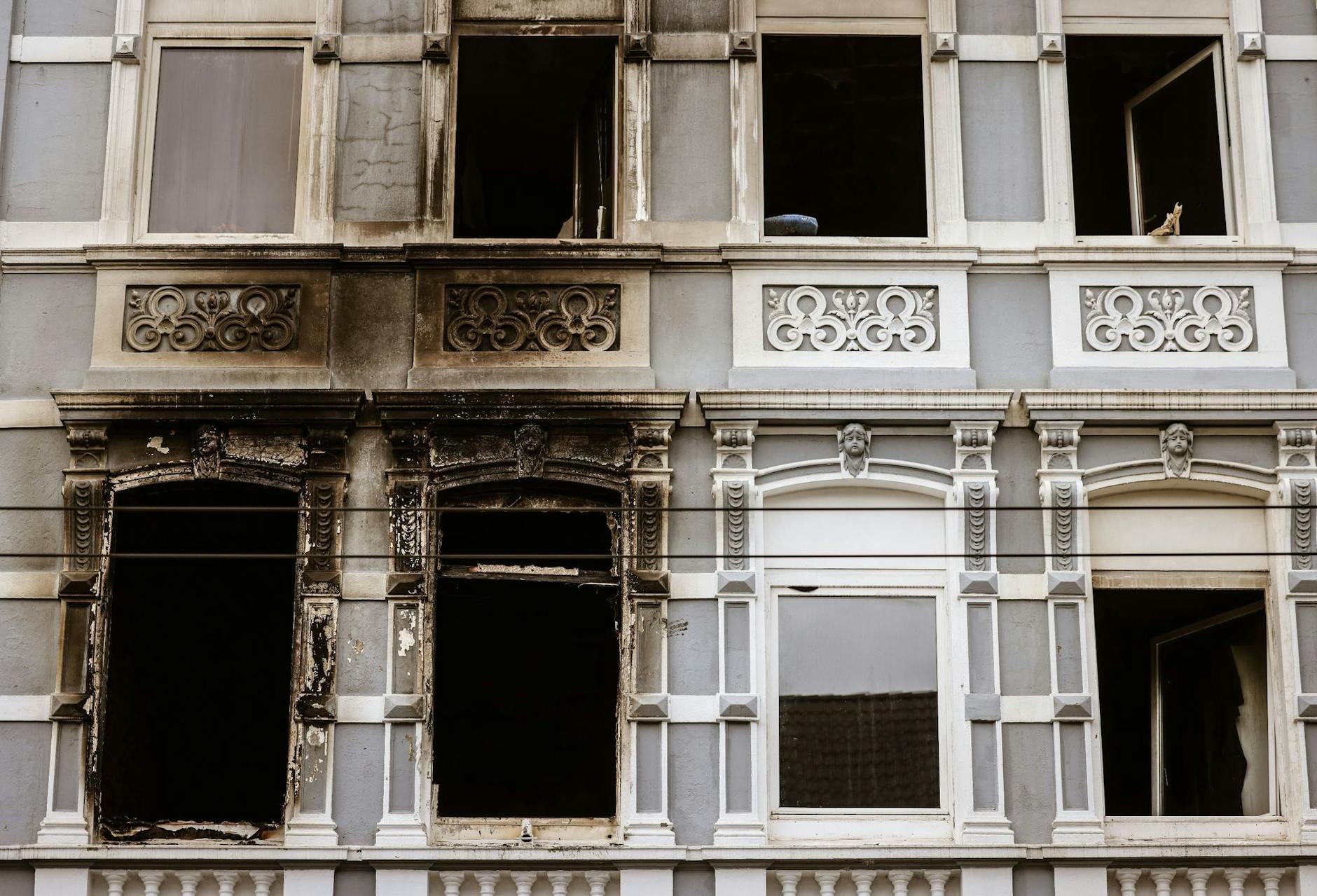 Brandspuren an der Fassade eines Wohnhauses in Solingen: Nach dem Großbrand in einem Mehrfamilienhaus mit vier Toten gehen die Ermittlungen zur Ursache weiter.