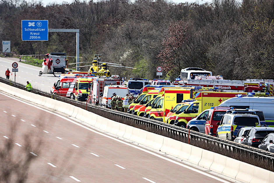 Sachsen, Schkeuditz: Einsatzfahrzeuge und Rettungshubschrauber stehen auf der A9 an der Unfallstelle. Bei einem Unfall mit einem Reisebus auf der A9 bei Leipzig sind mindestens vier Menschen ums Leben gekommen.