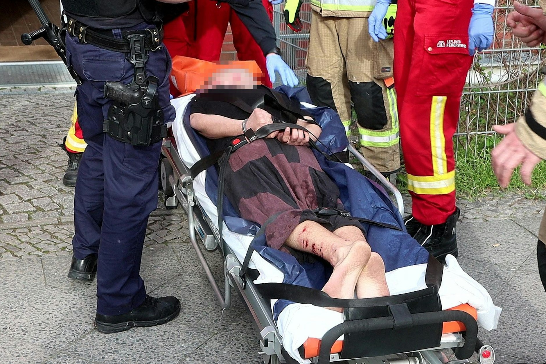 Der Mann wurde gefesselt und auf einer Trage abtransportiert. Er wurde in ein nahe gelegenes Krankenhaus gebracht.