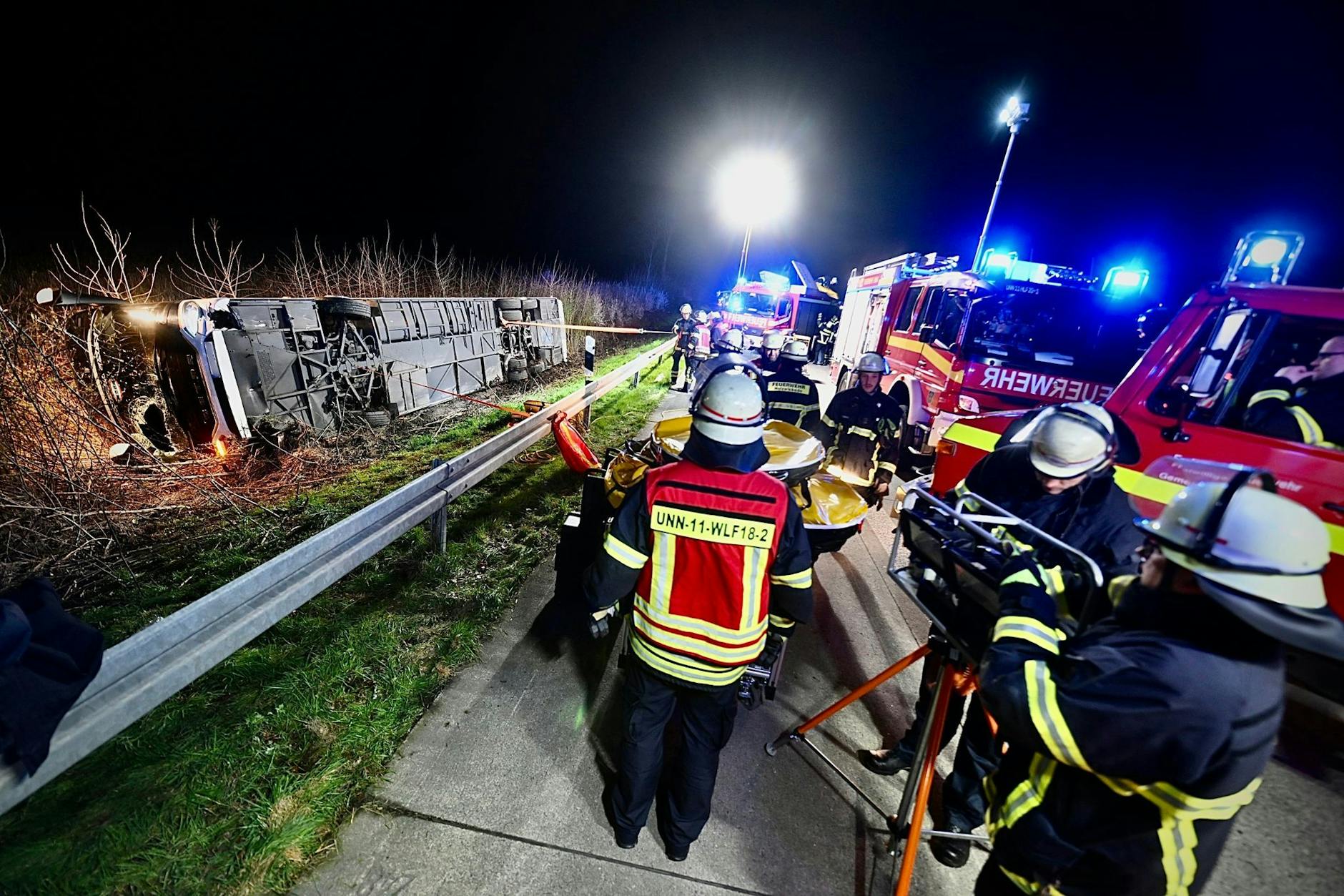 Einsatzkräfte der Feuerwehr arbeiten an einer Unfallstelle auf der Autobahn 44 an dem verunfallten Bus. 